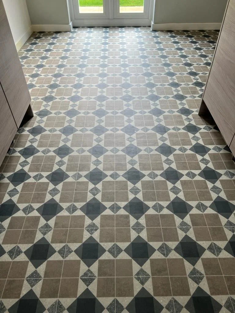 Patterned tile floor in a room with glass door leading outside.