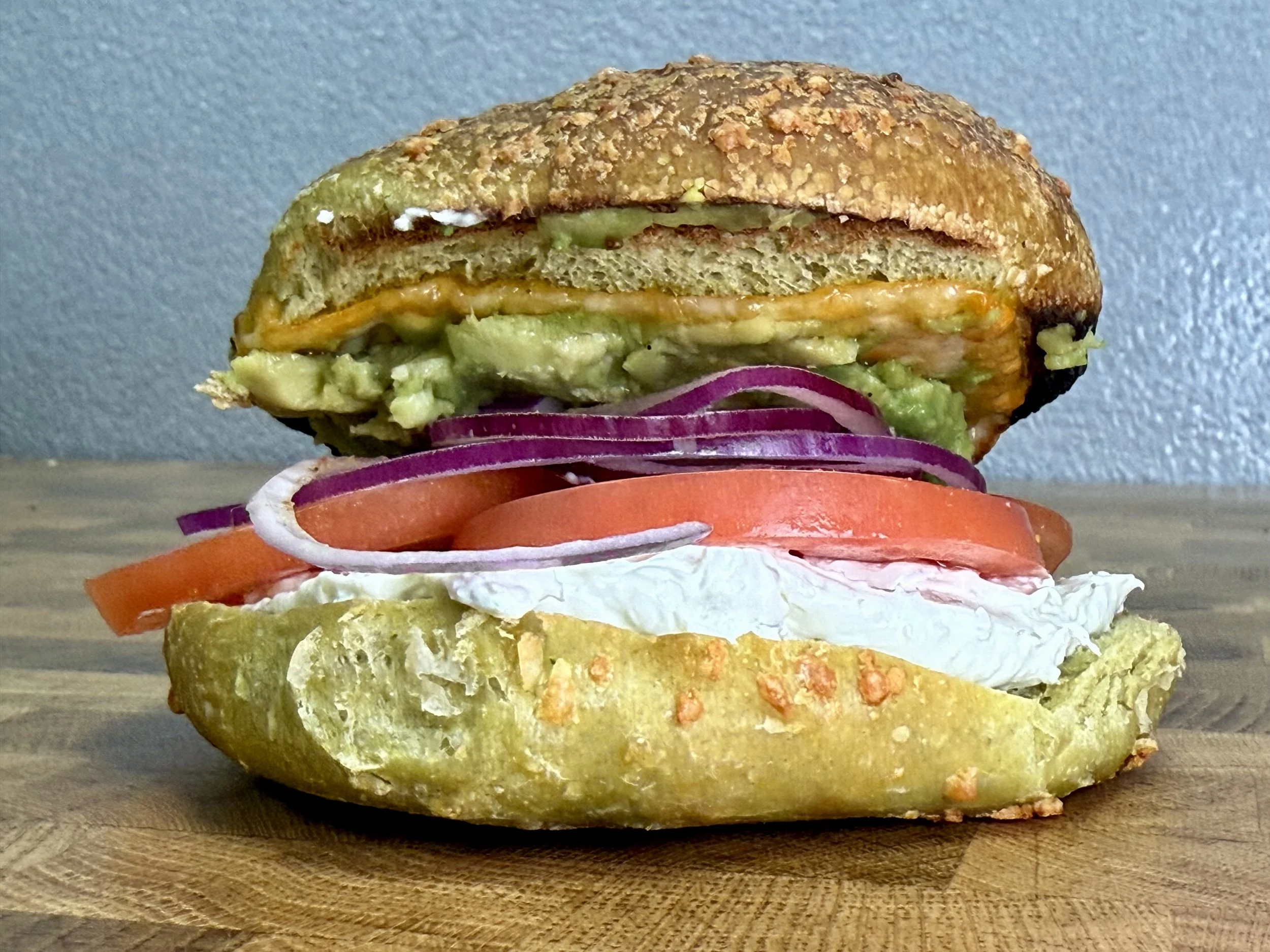 Close-up of a lunch veggie sandwich on a pesto bagel