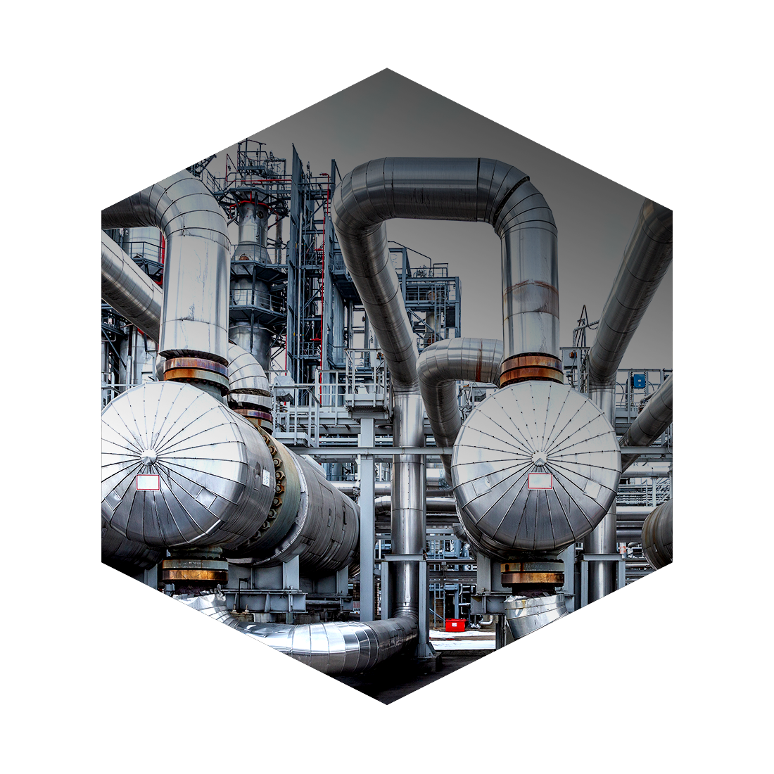 Industrial plant with large metallic pipes and tanks, part of a factory or refinery.