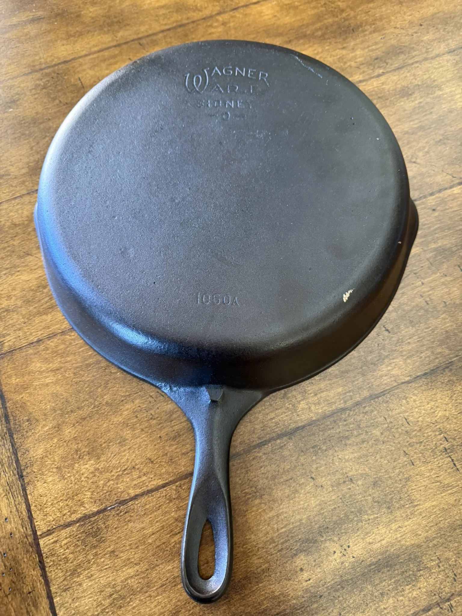 Cast iron skillet with markings on the bottom indicating it is a Wagner Ware Sidney model.