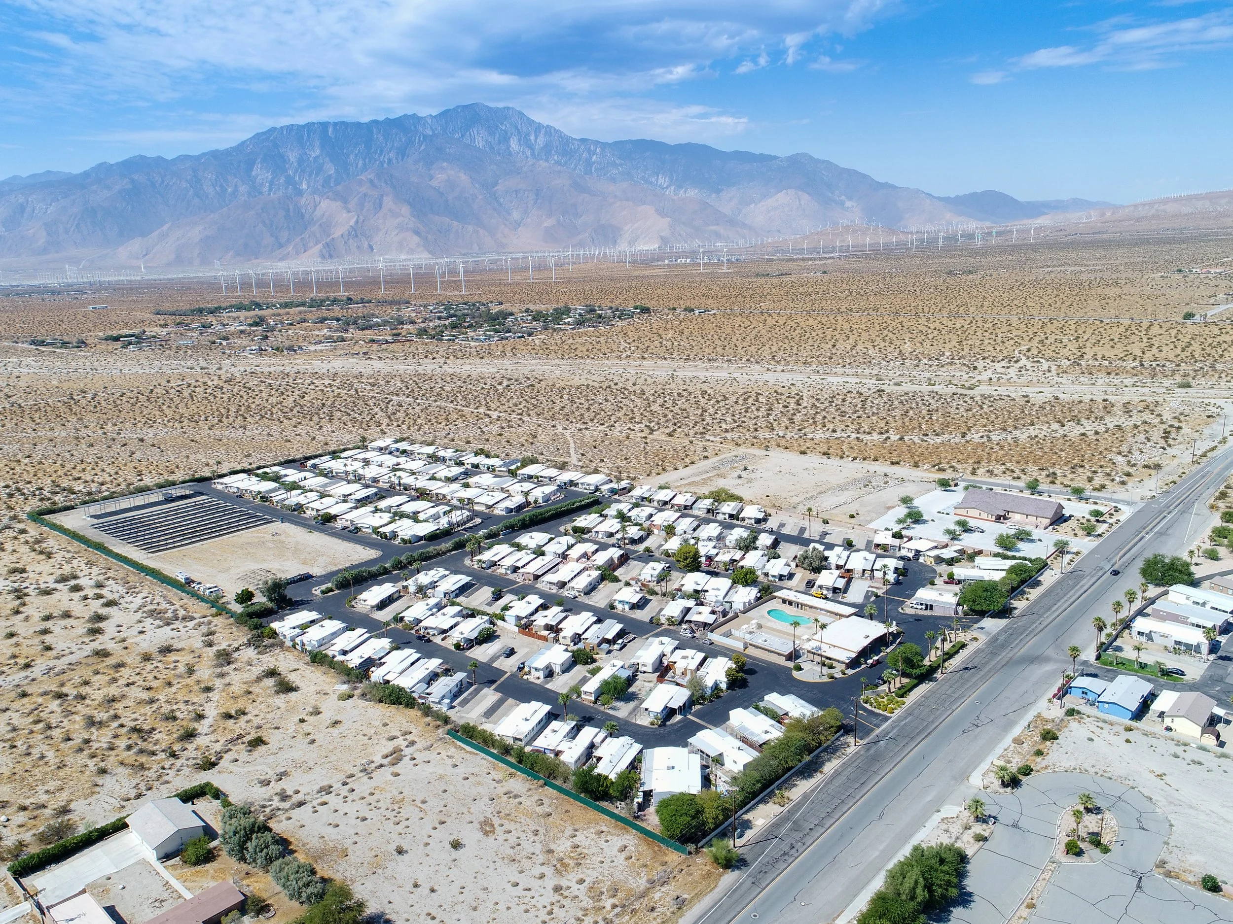 Aerial view of Park West Mobile home Community, with a desert landscape and mountain views