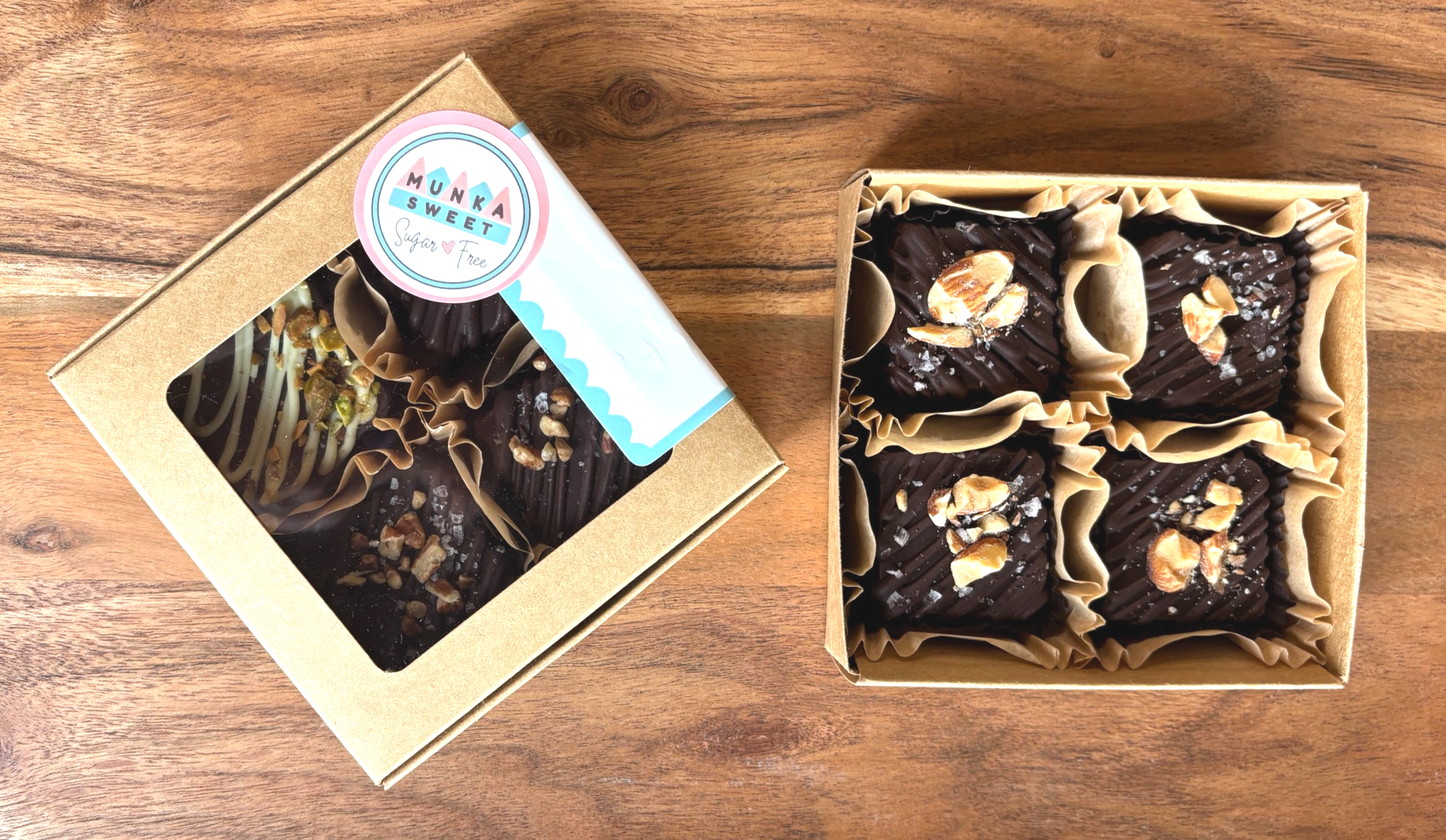 Box of dark chocolate truffles topped with chopped nuts, presented on a wooden surface.