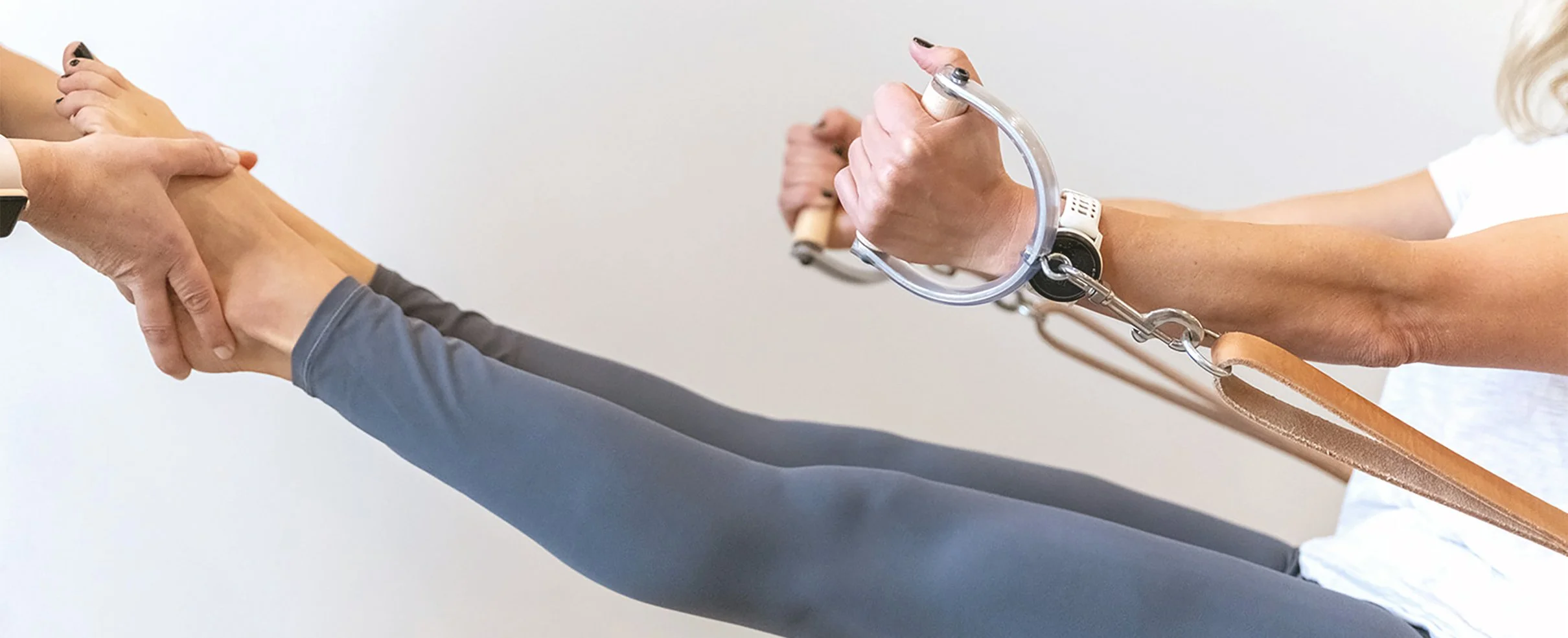 A healthcare professional using a crutch to assist a patient with walking, supporting their arm.