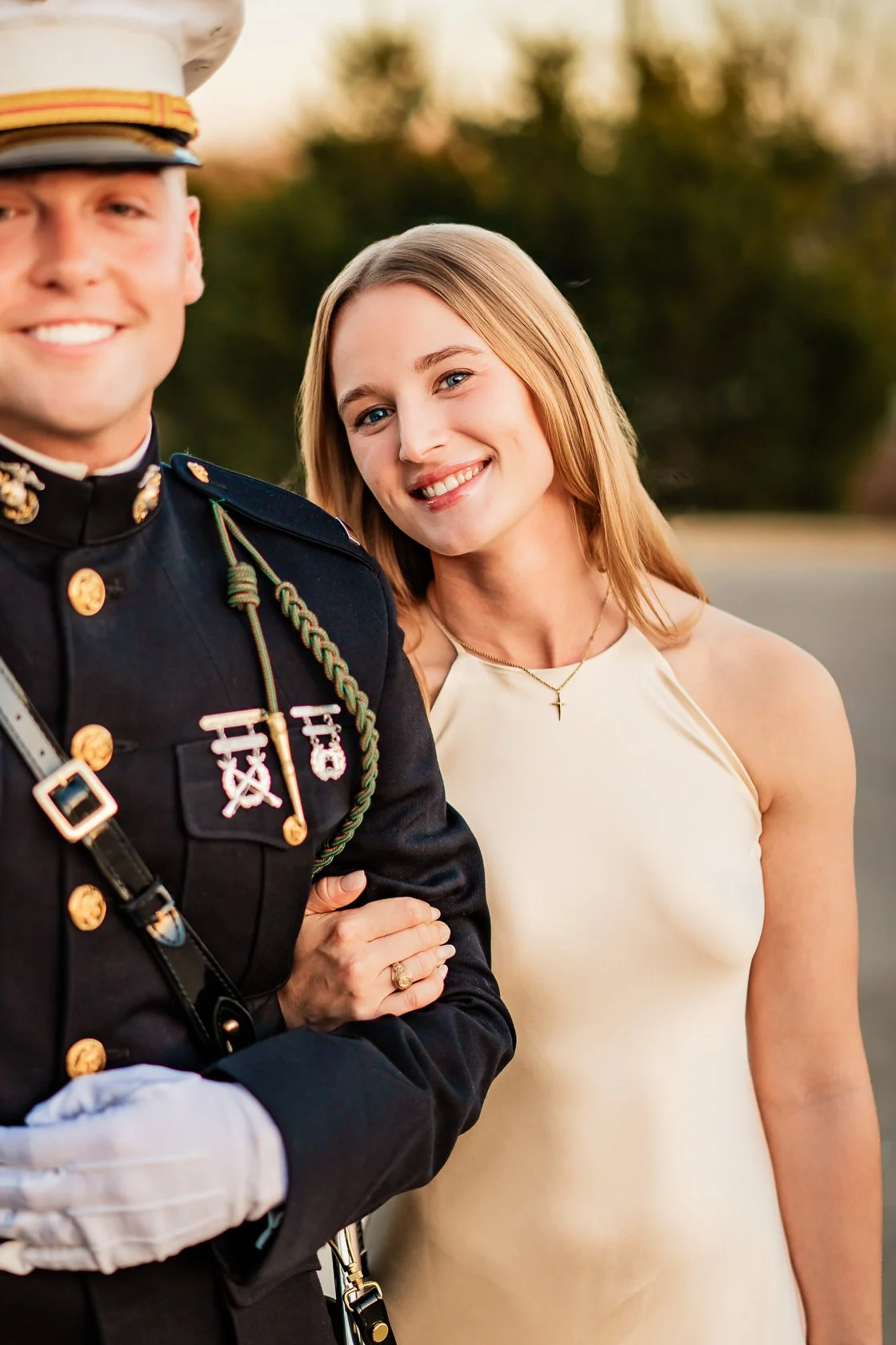 A smiling woman with blonde hair standing next to a man in military uniform.