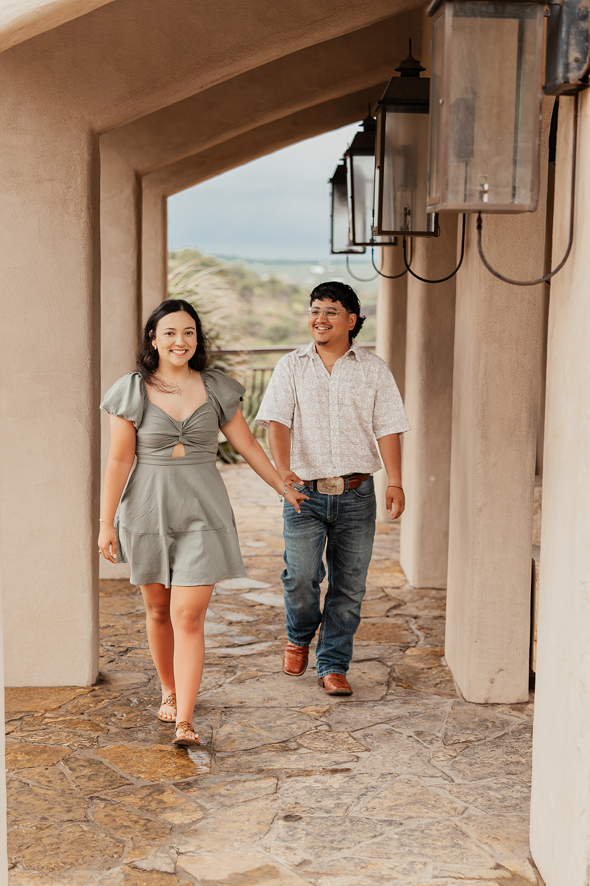 A young couple walking hand-in-hand through a porch, smiling and enjoying each other's company