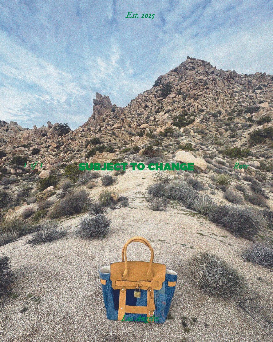 A desert trail leading to rocky mountains under a partly cloudy sky, with a travel bag on the ground in the foreground.