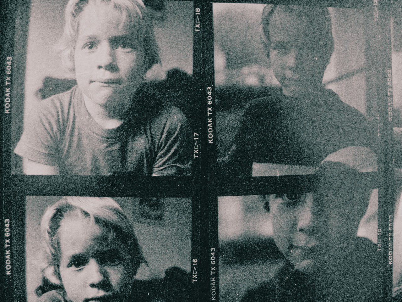 Four black and white photocards featuring close-up portraits of children, with two children appearing on the top row and two on the bottom row, framed within a photo strip layout.
