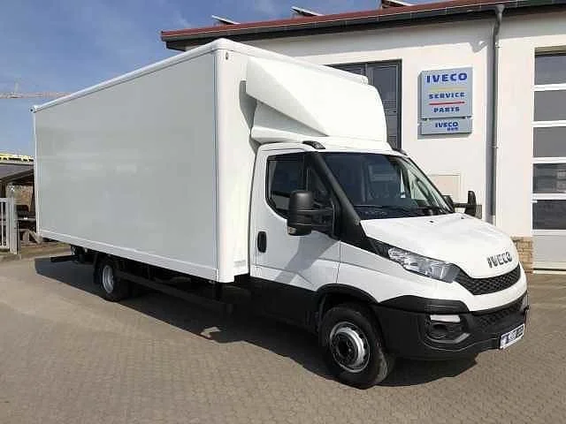 Weißer Transporter vor einem Imbiss mit IVECO Logo, Service und Ersatzteil-Schild