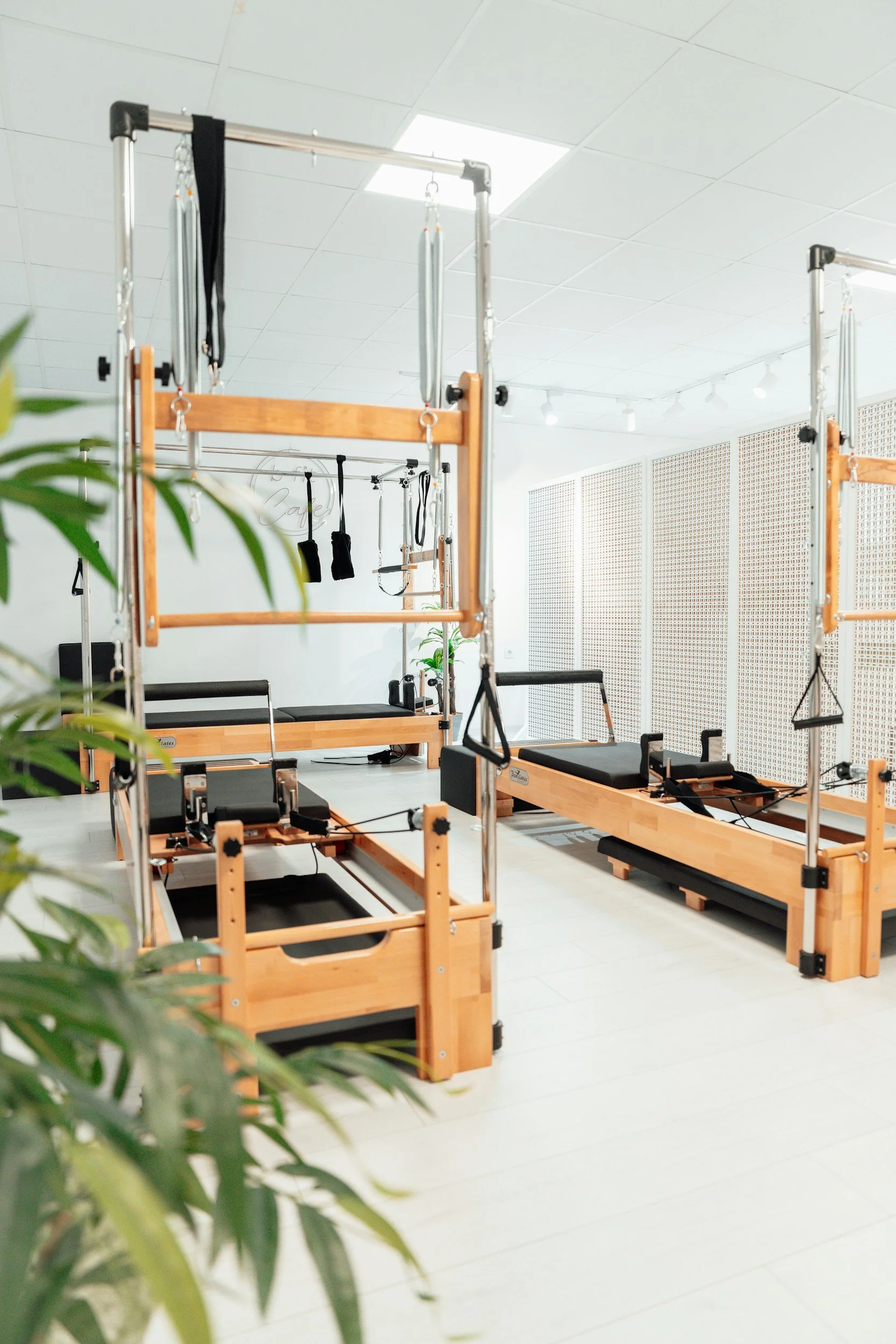 Reformer Pilates studio with wooden Reformers, Pilates equipment, and white walls