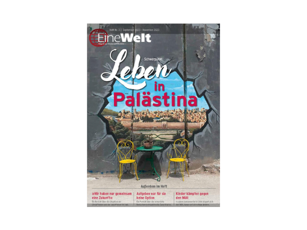 Titelseite eines Magazins mit dem Titel 'Leben in Palästina', zeigt eine zerbrochene Wand mit Blick auf eine Stadt und zwei gelbe Stühle vor einem kleinen Tisch
