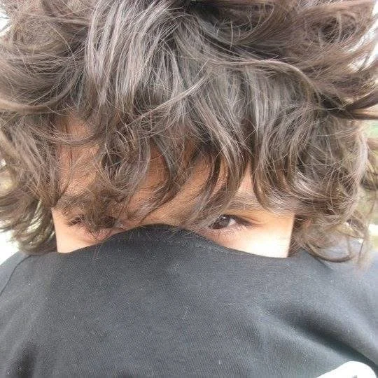 Danny Ashtiani partially covering their face with a black object or piece of clothing