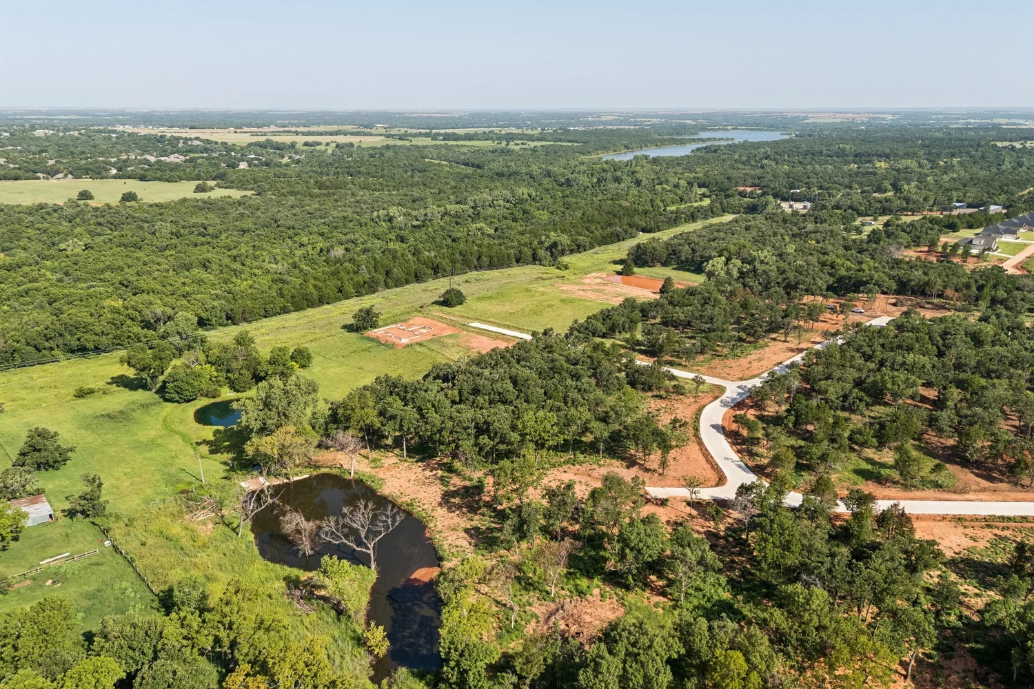 Aerial view of Oklahoma acreage showing the lots, tree line and pond