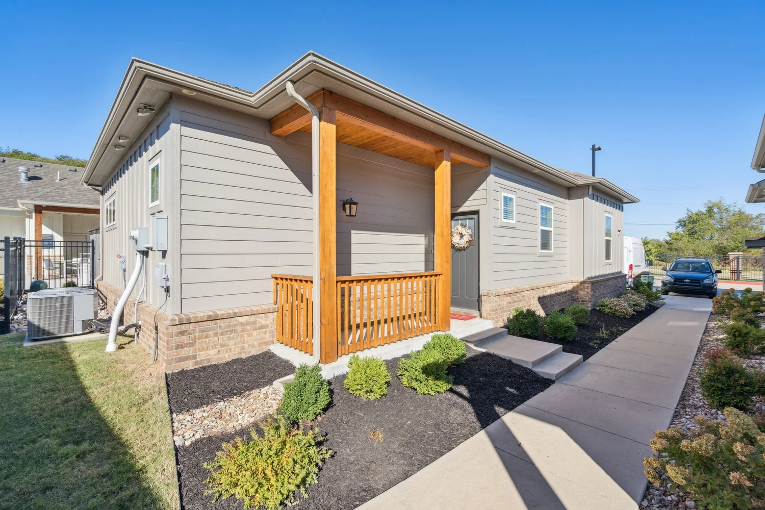 Exterior of an Oklahoma multifamily community with a covered entry and landscaped walkway