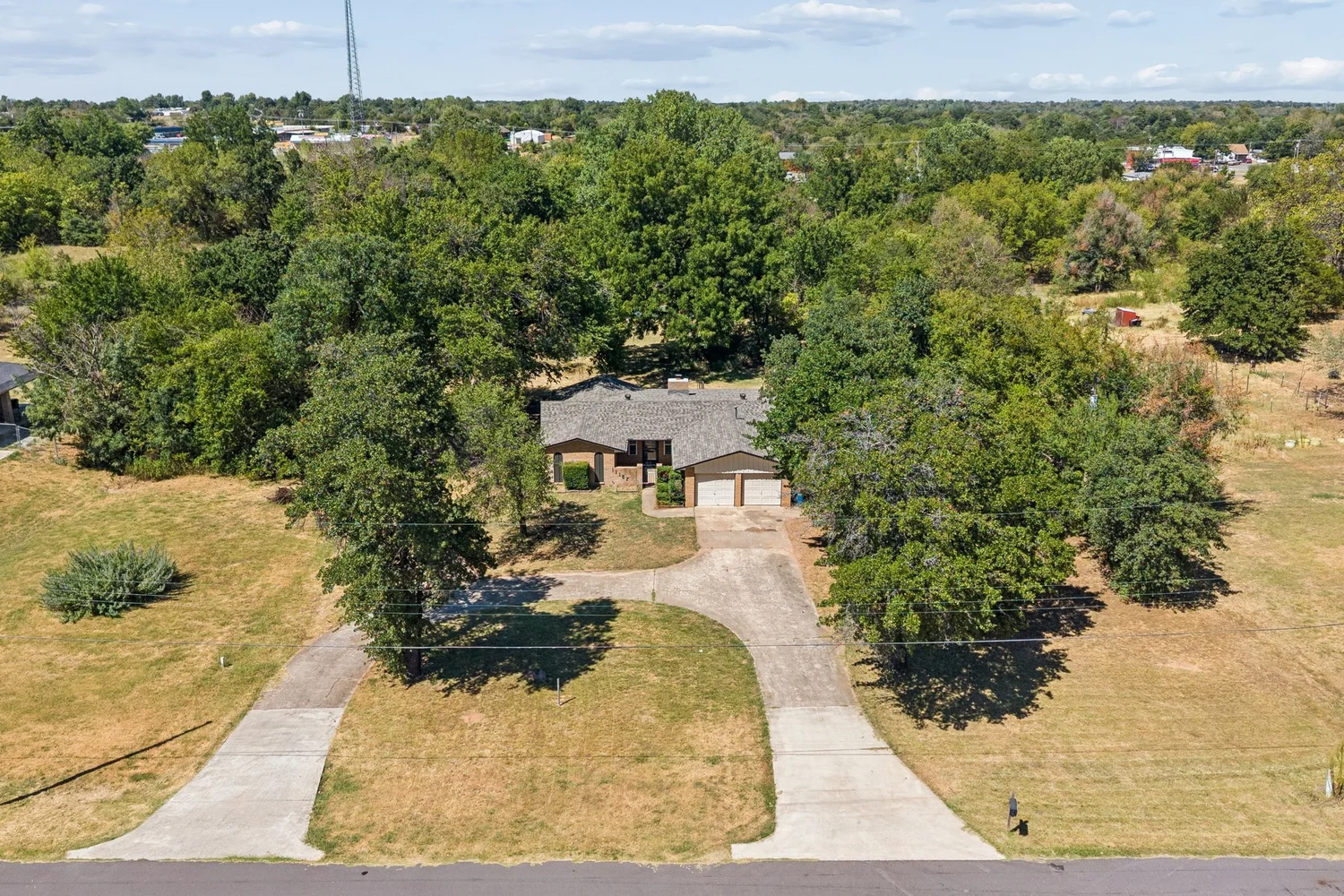 Aerial view of an Oklahoma property and its driveway from mid elevation