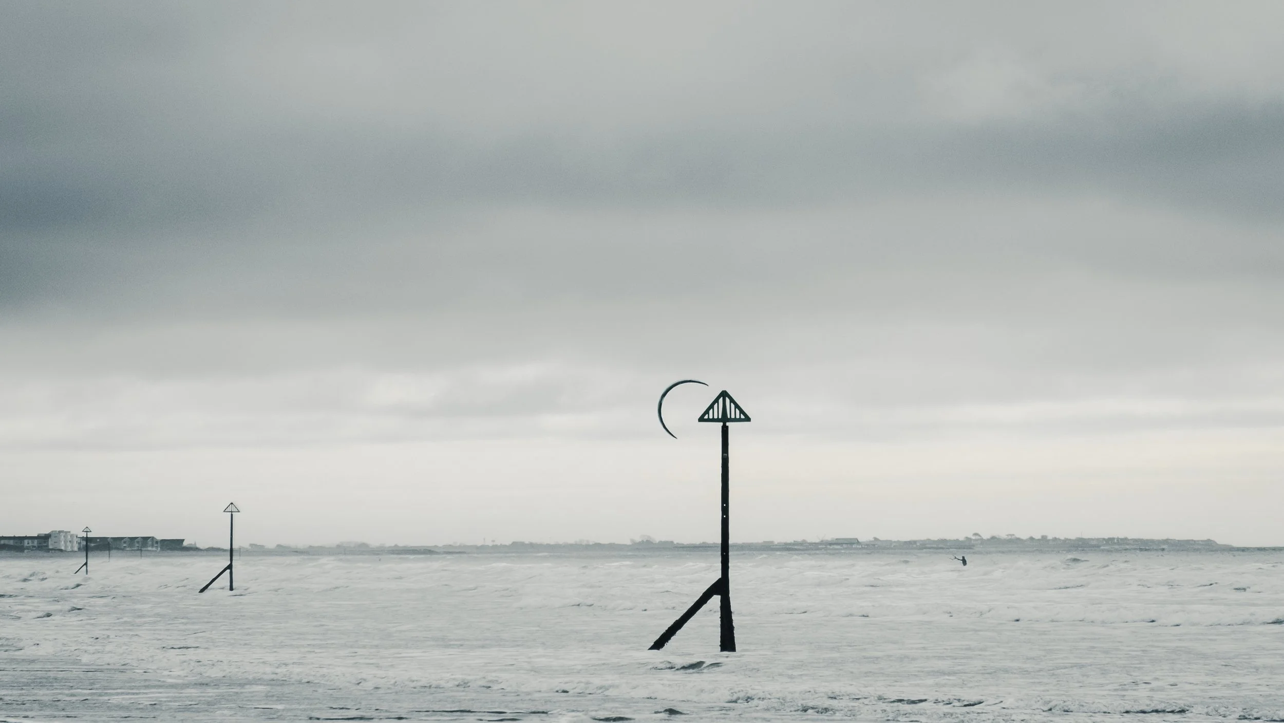 Stormy ocean view with wave-mounted warning signs and cloudy sky in the background
