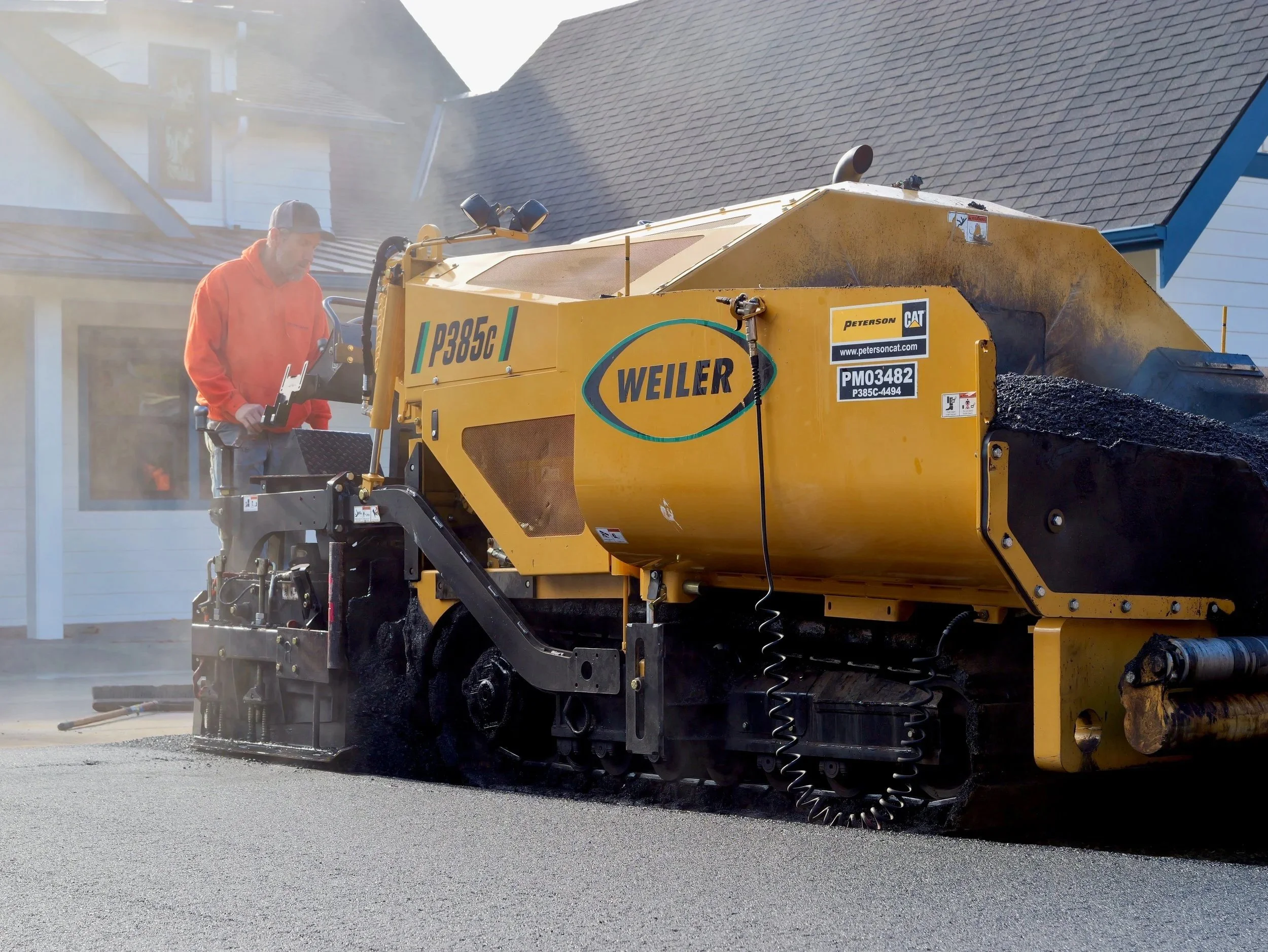 On Point Paving using an asphalt paver to lay down asphalt on a driveway