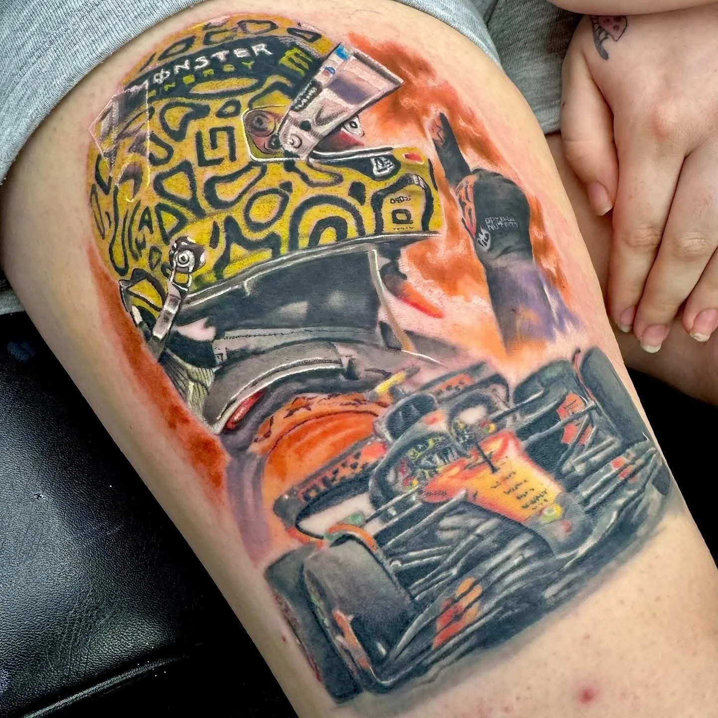 Realistic tattoo of formula one racing driver lando Norris and his F1 car