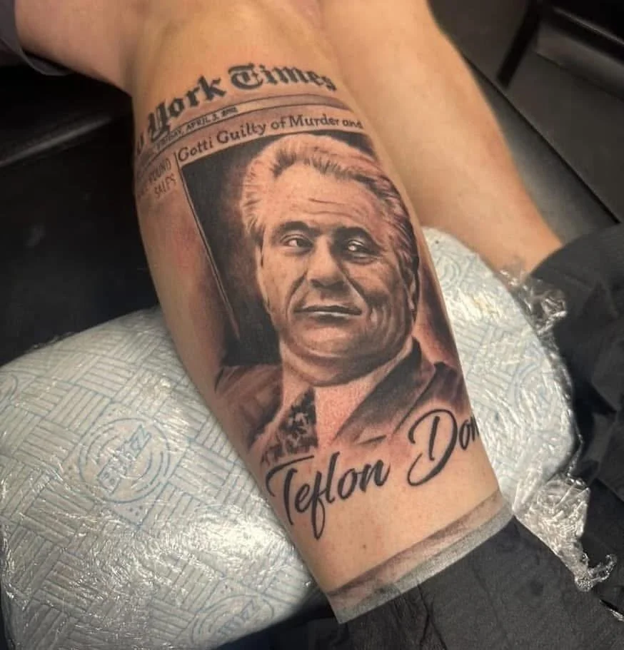 Tattoo of a man in a suit with the name "Teflon Don" and a newspaper headline referencing John Gotti, with the name "Mark Times" at the top.