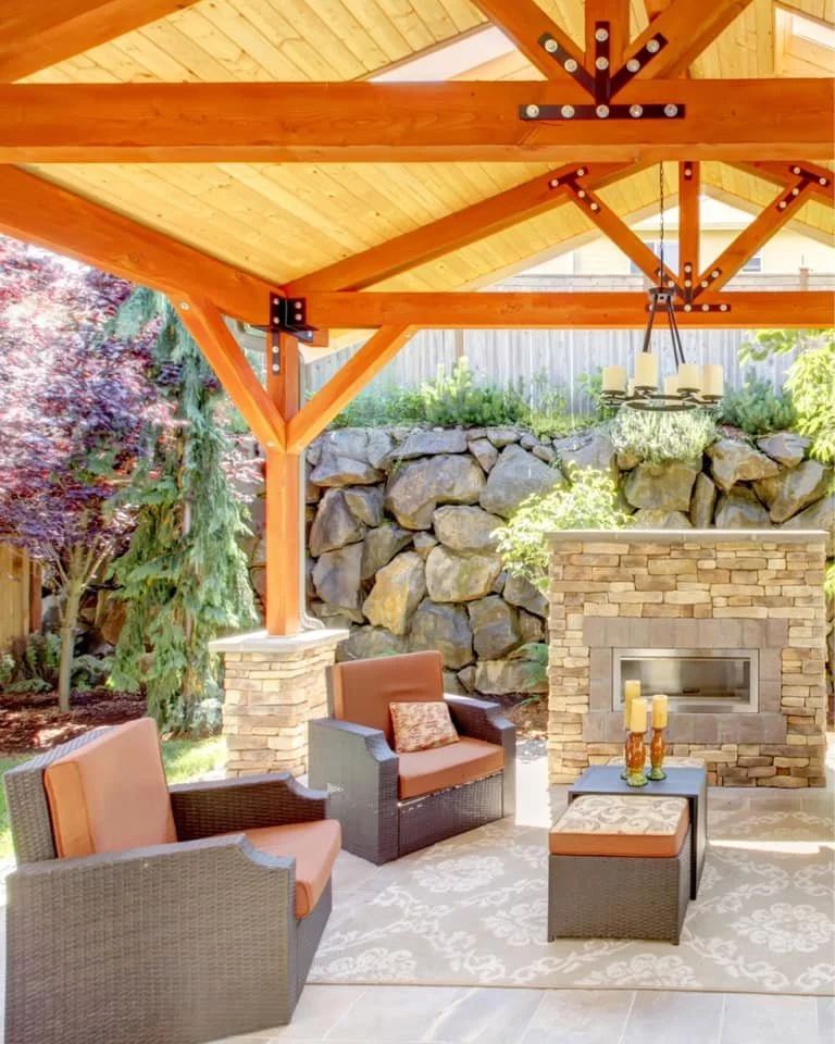 Large outdoor covered backyard patio with custom built wood gazebo, wood rock gas fireplace and patio lounge seating