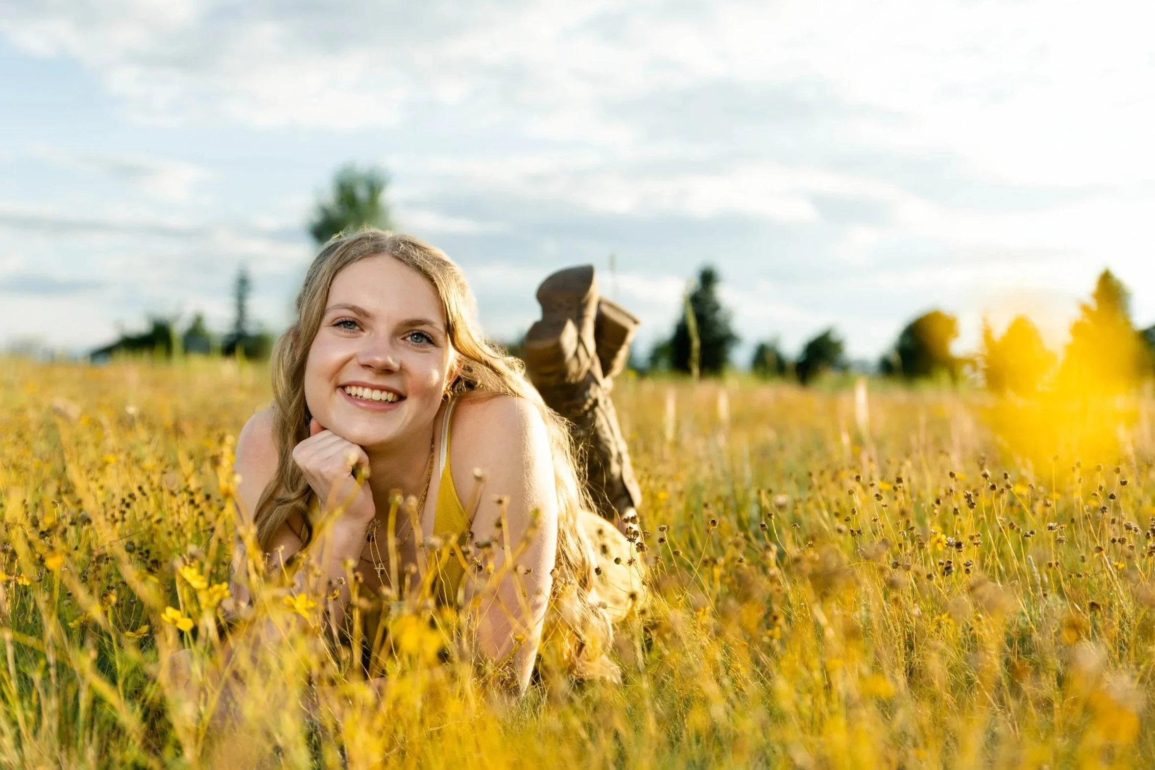 High school senior girl laughing in golden field Colorado Springs outdoor portrait session