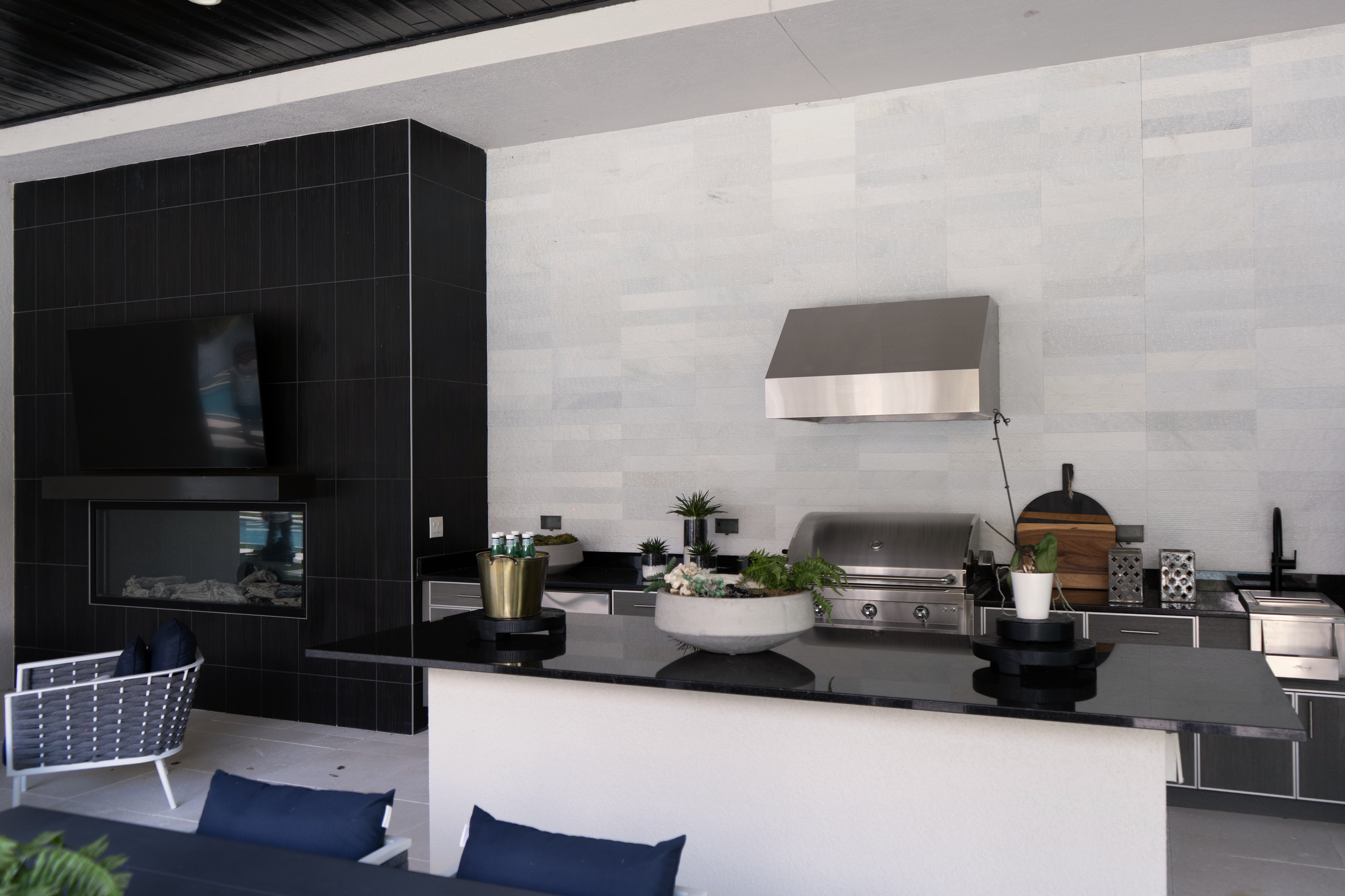 Outdoor kitchen area with tile flooring and covered seating