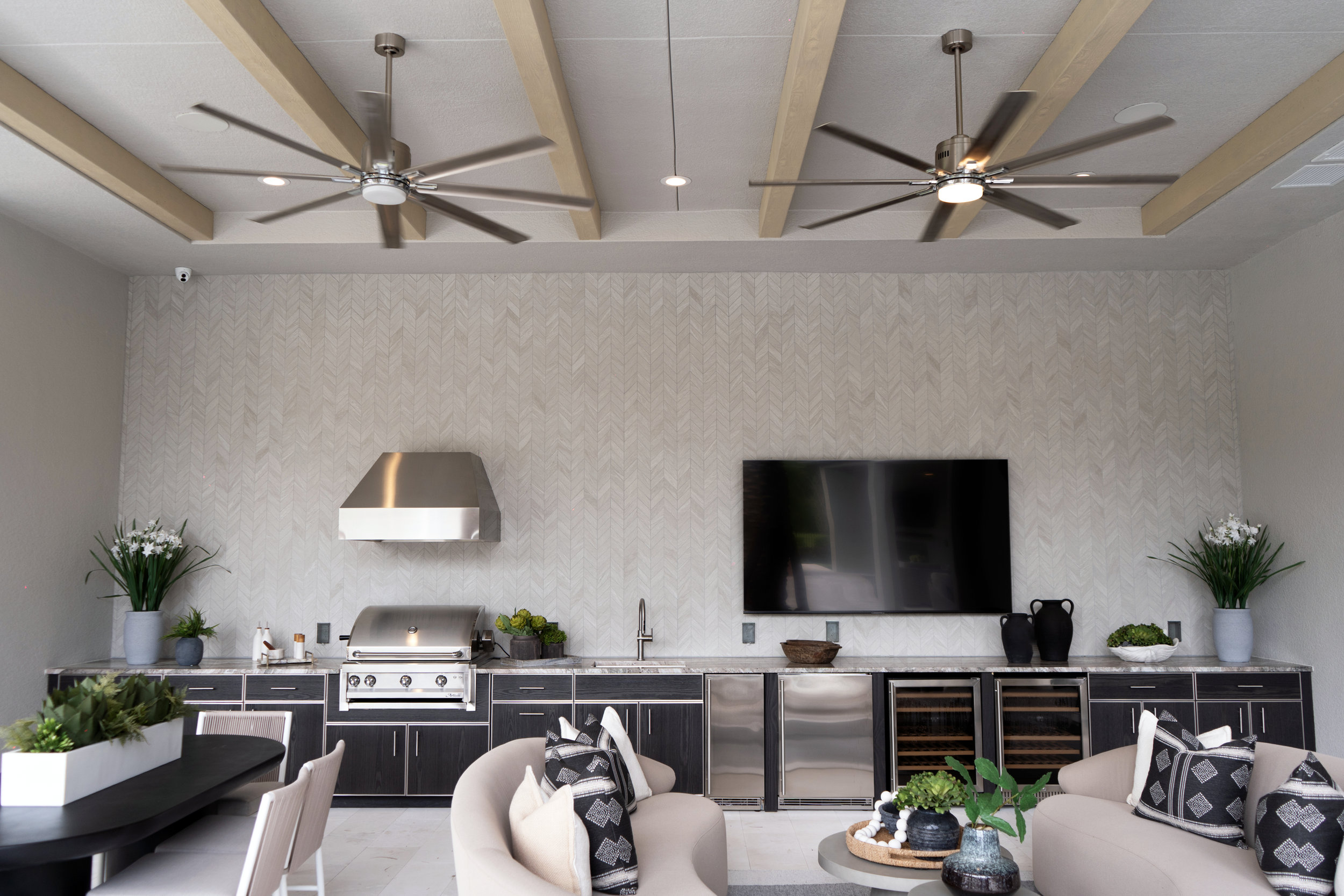 Outdoor kitchen area with tile flooring and covered seating