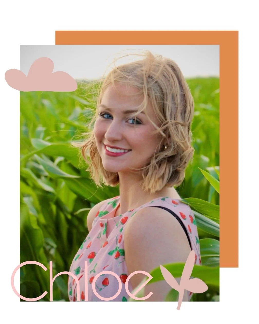 Portrait of a smiling woman with blonde hair, wearing a sleeveless dress with red berries, standing in a green cornfield with a background of blue sky.