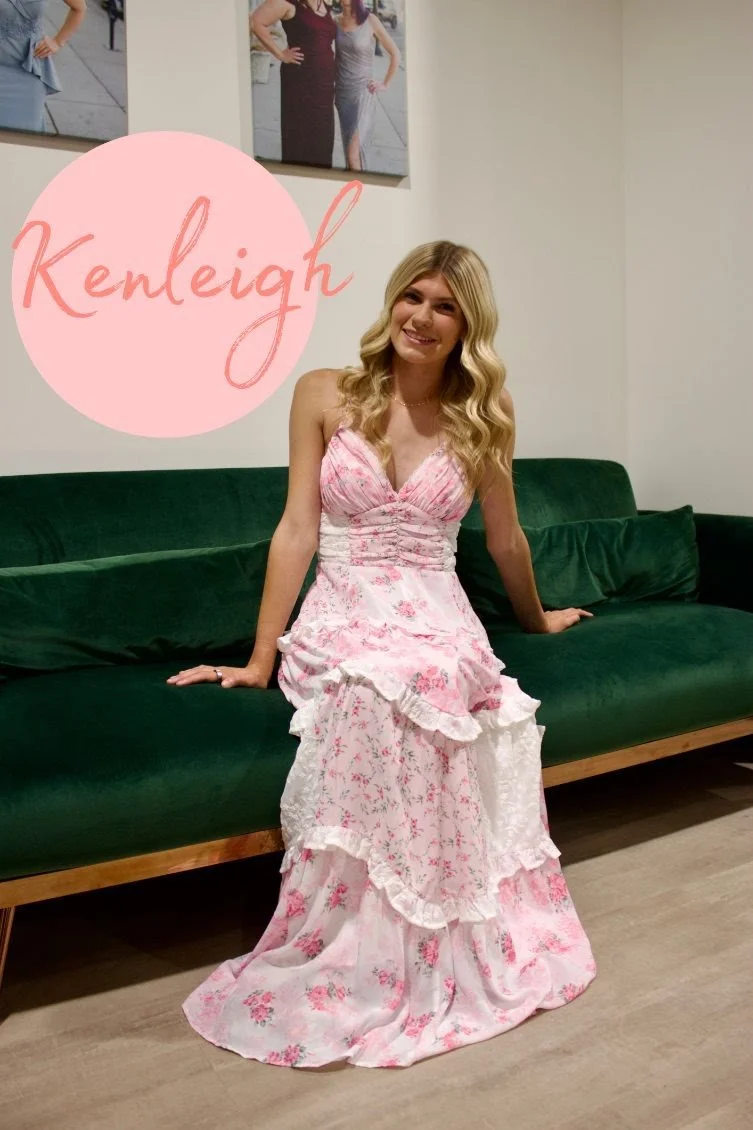 A young woman with long blonde hair sitting on a green velvet sofa, smiling, in a room with white walls. There is a gold pillow on the sofa and photo prints on the wall behind her. The image has overlay graphic elements, including the name 'Carissa' and decorative shapes.
