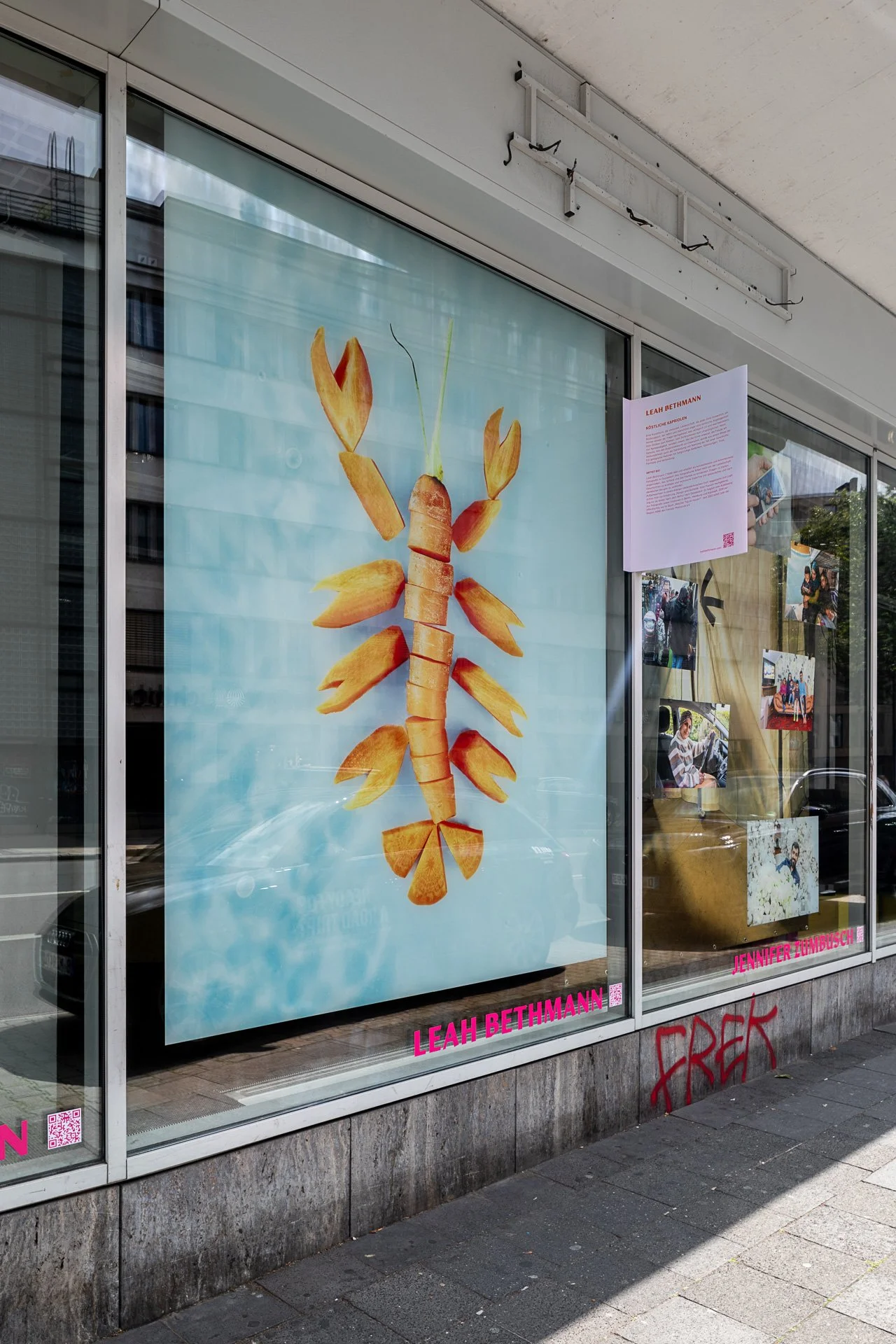 Schaufenster mit einem Kunstwerk, das aus einer Anordnung von Kartoffelchips und Gemüsescheiben die Form eines Skorpions bildet.