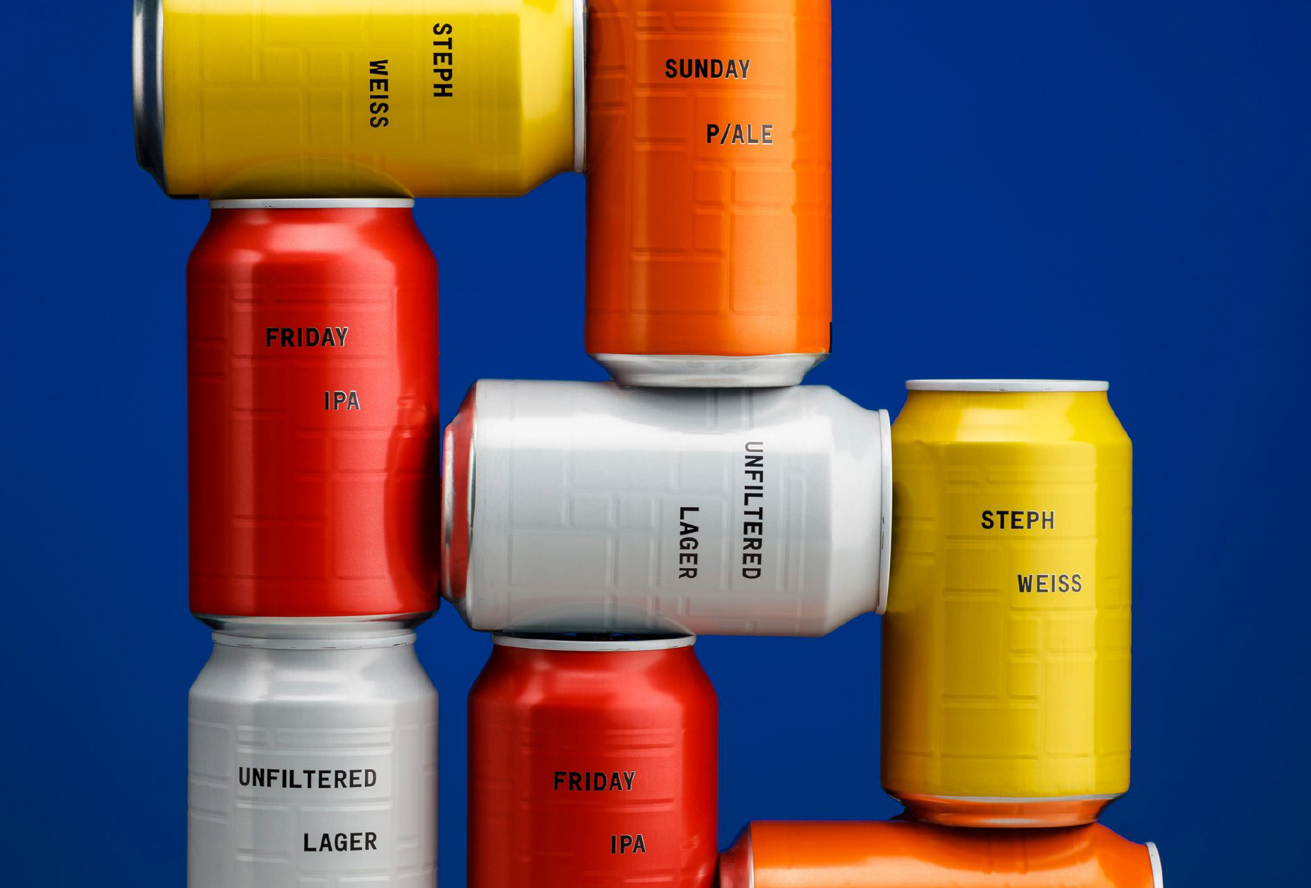 Mehrere farbige Bierdosen, die auf einem blauen Hintergrund aneinandergereiht sind. Die Dosen haben verschiedene Beschriftungen wie 'Friday IPA', 'Unfiltered Lager', 'Sunday P/ALE', 'Steph Weiss' und 'Weiss'.