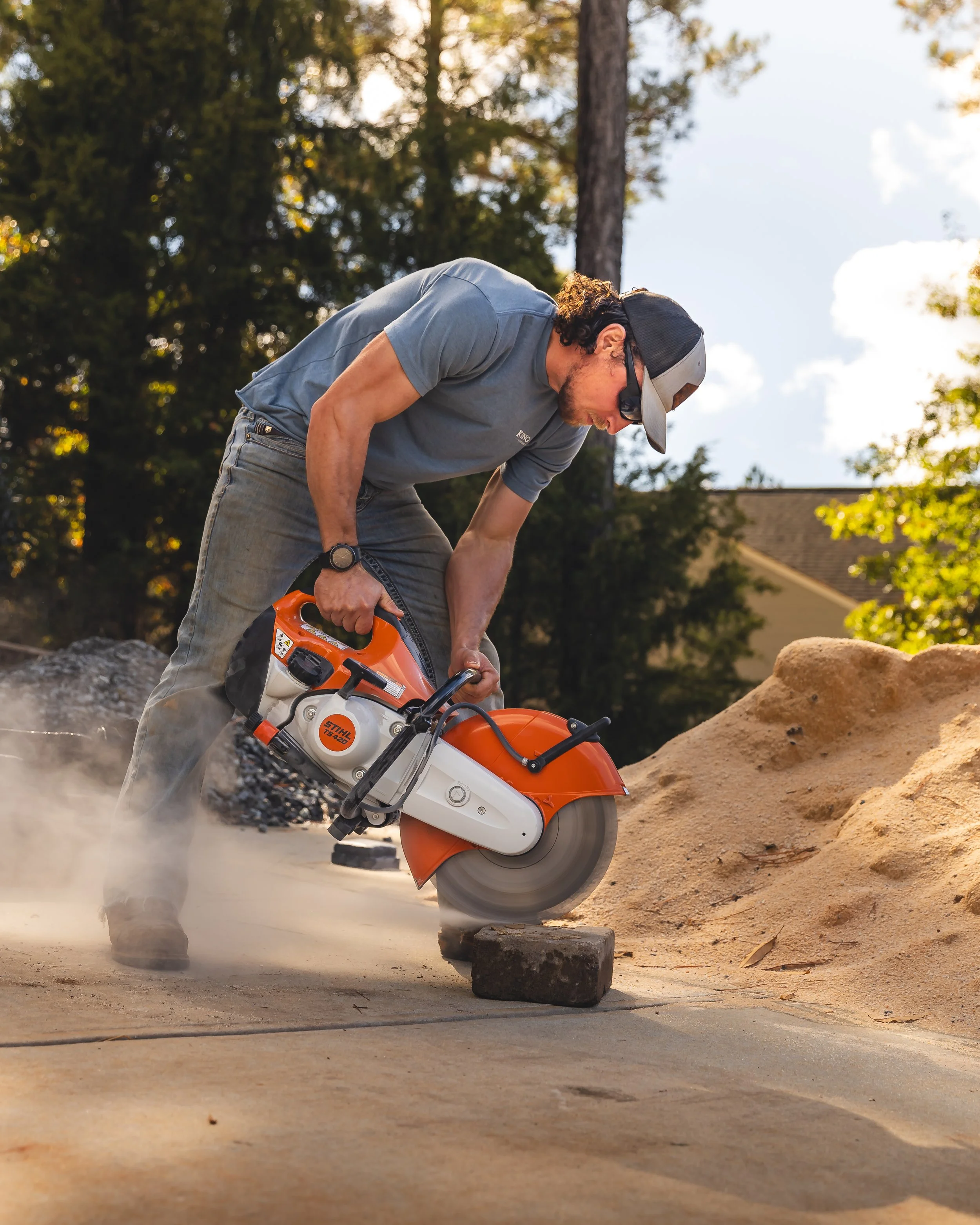 kingston-artist-cutting-block-with-large-concrete-saw-sunlight-bright-image