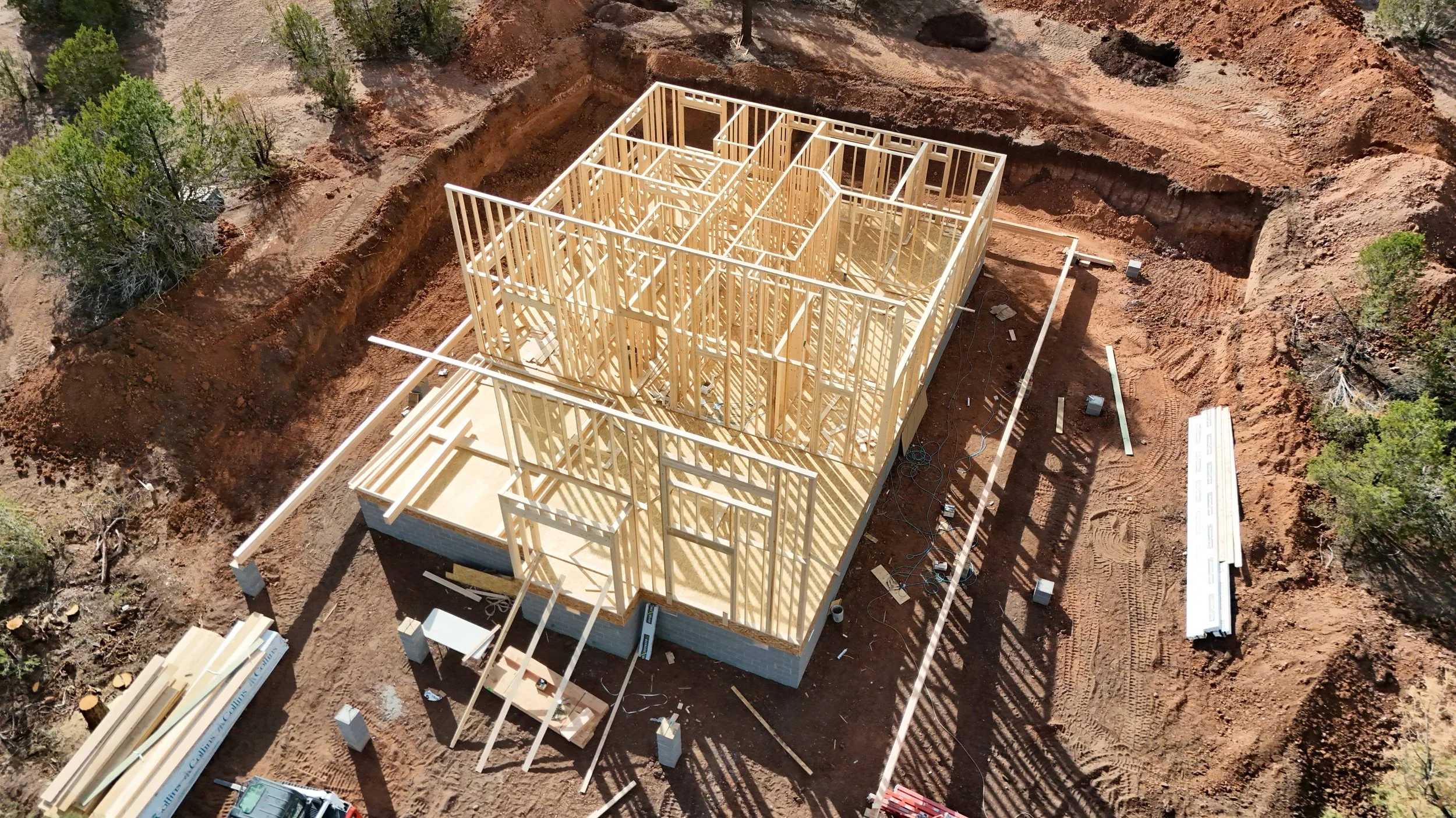 An aerial view of a residential house frame during construction.