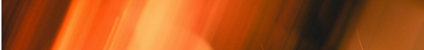 Close-up orange moving light with a dark background.