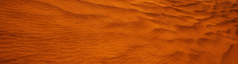 Close-up of orange sand dunes with rippled texture.