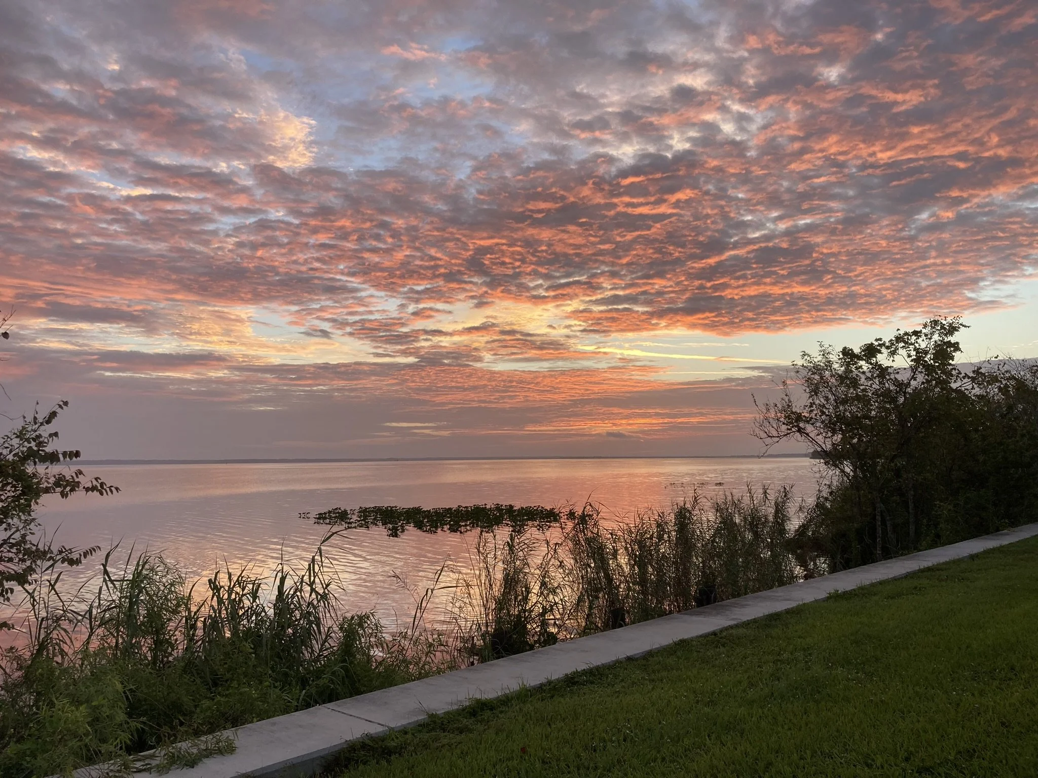 Orange cloudy sunrise reflecting on the lake