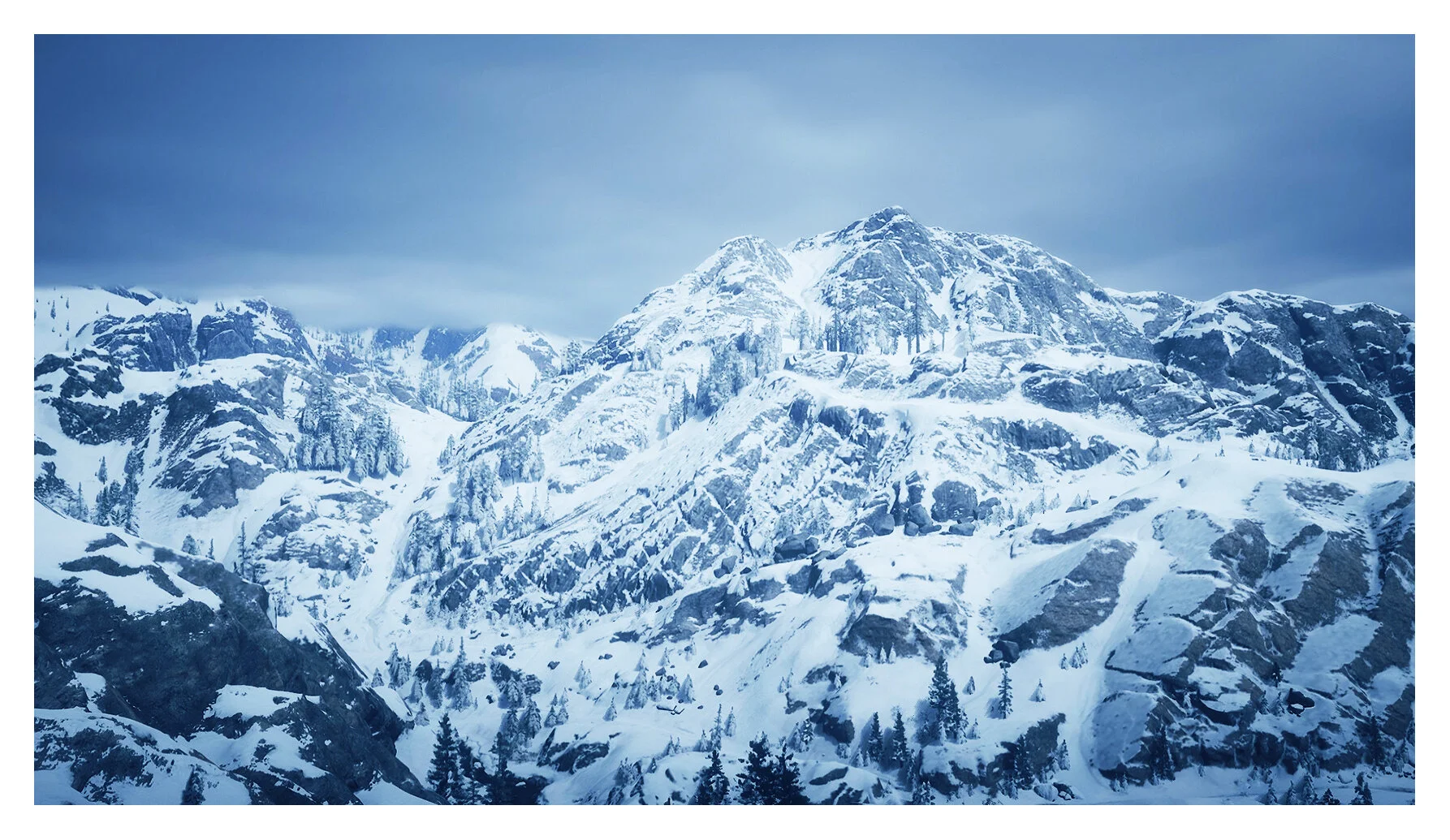 Snow-covered mountain range with rocky peaks and evergreen trees under a cloudy sky.