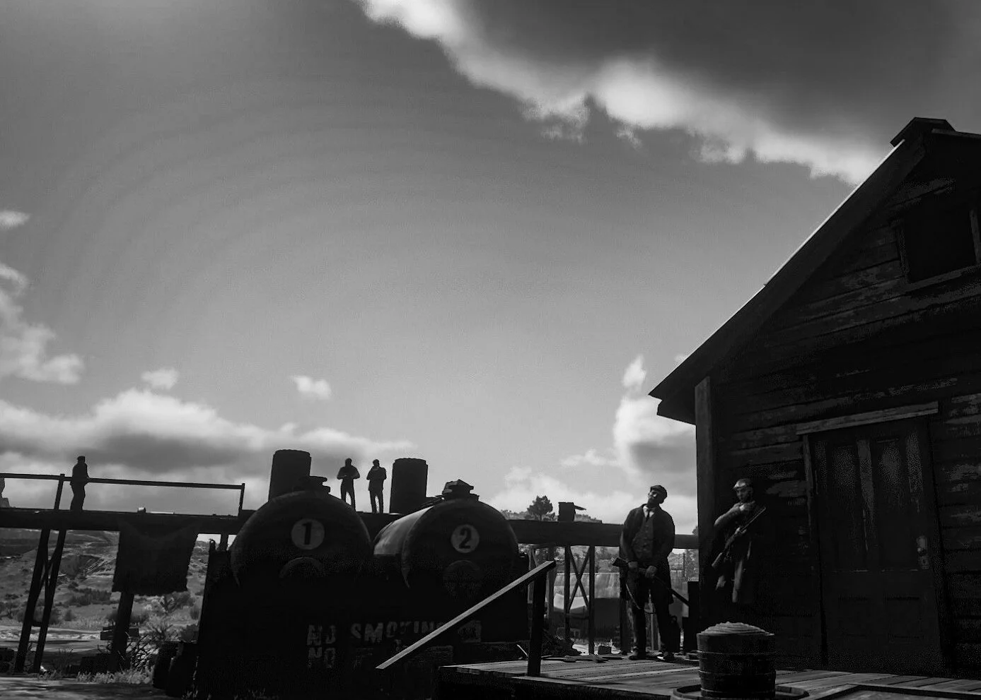 Black-and-white scene with a wooden building on the right, four men standing on a platform, two with guns, and three more in the background near the platform, with smoke stacks labeled '1' and '2' and a landscape in the distance.