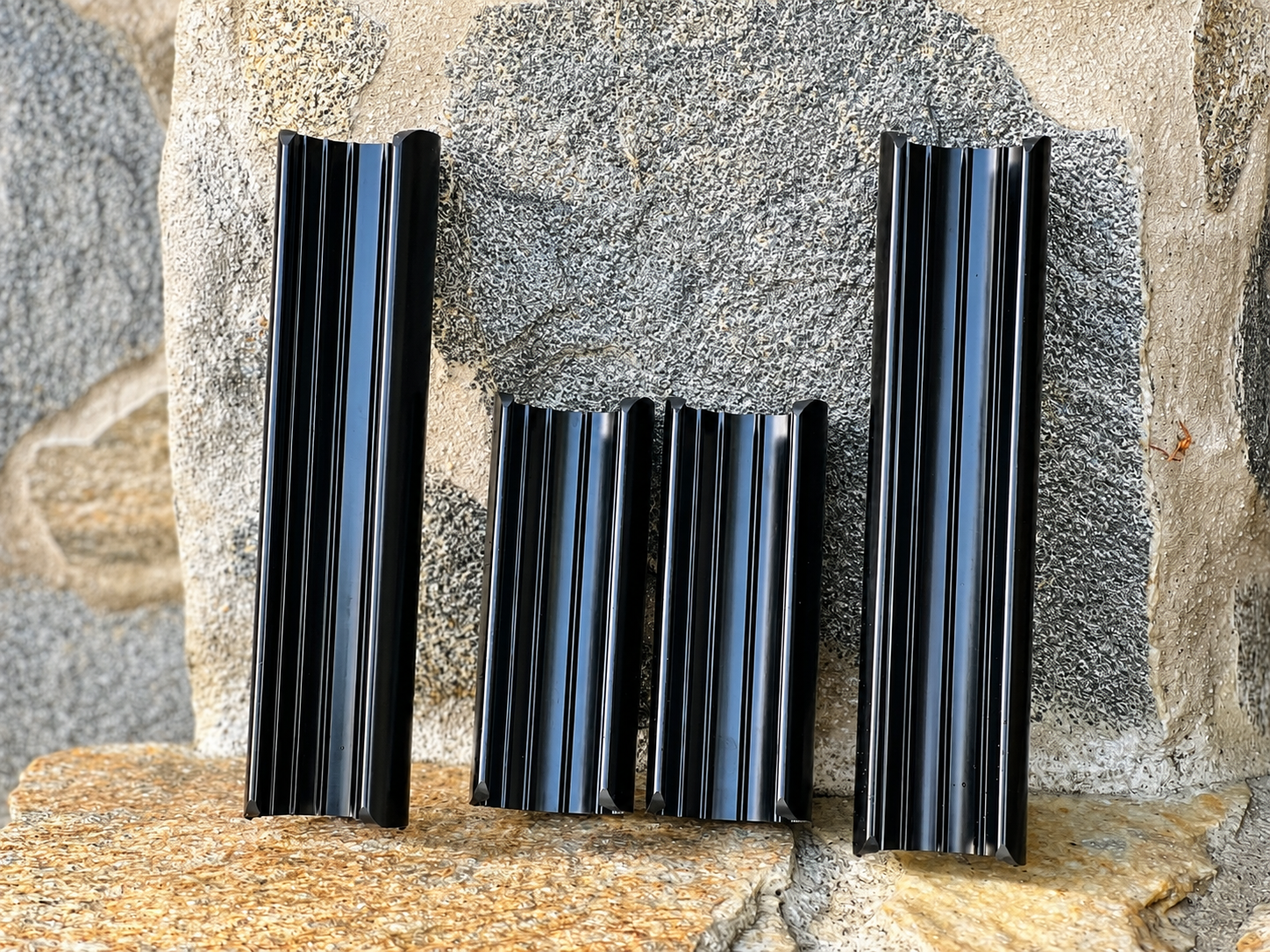  RokPro four-piece dirt bike fork guard set with two 6-inch and two 10-inch guards. arranged vertically on a rocky surface.