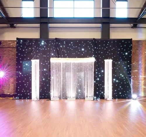 A sparkling starry backdrop with flowing jewelry or fabric display at an indoor event space.