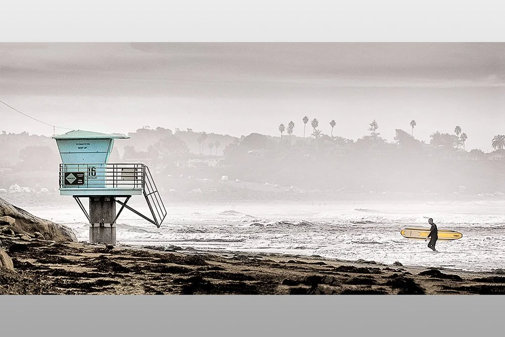 surfer coming out of the water at lifeguard tower  in encinitas california.jpg