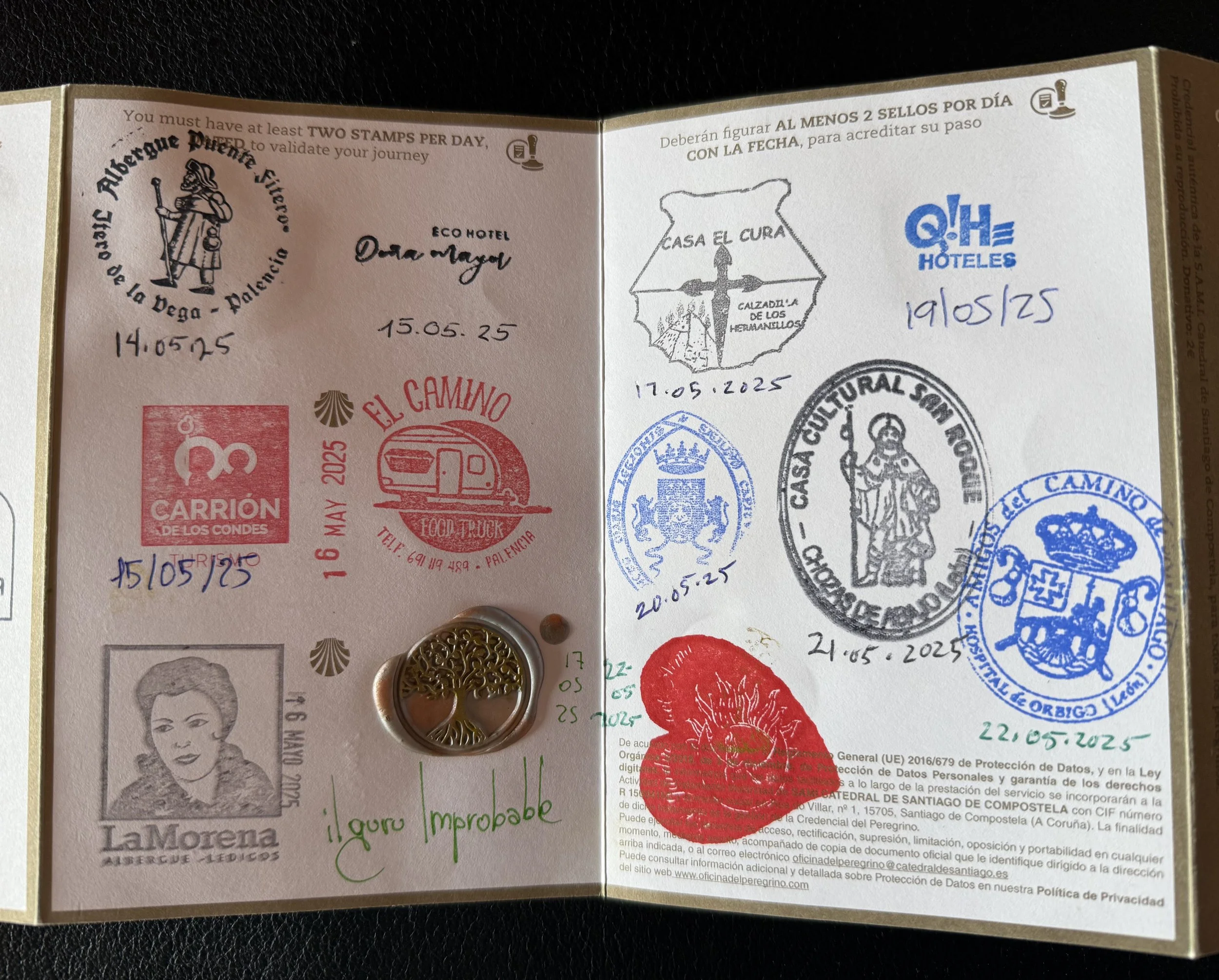 Open passport page with multiple stamped marks, signatures, and a decorative metal charm. The stamps are from various locations and dates, and handwritten notes are also visible.