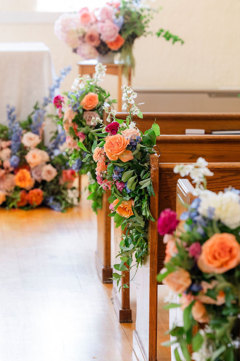 Bright floral arrangements lining the ceremony aisle during a traditional Wyoming wedding ceremony.
