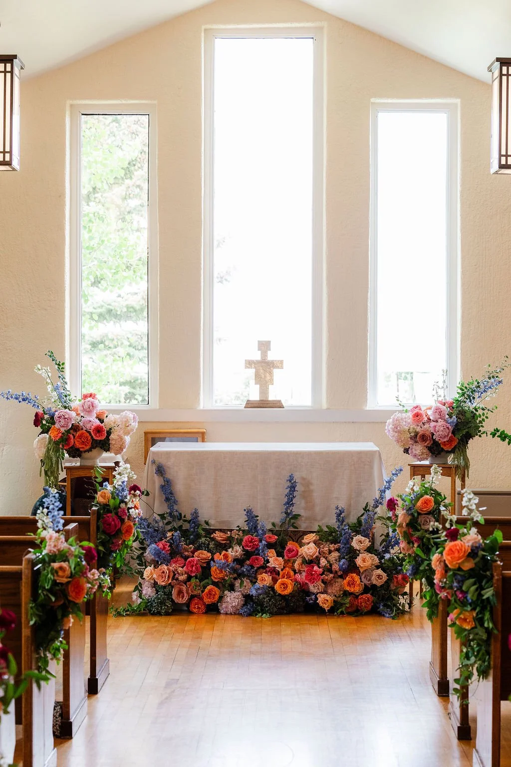 Colorful church floral ceremony installation inside St. Francis of the Tetons.