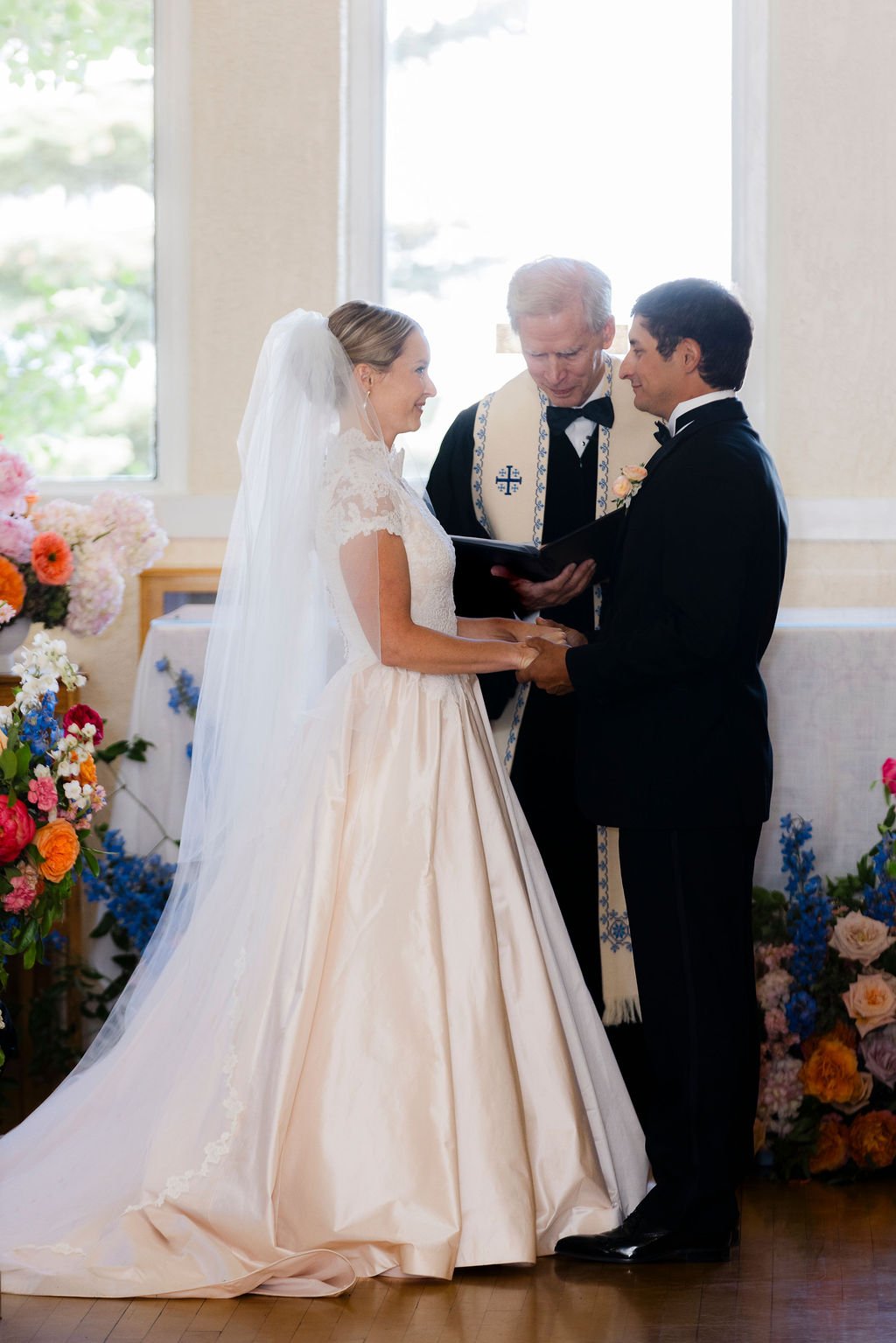 Bride and groom exchanging vows during their ceremony at St. Francis of the Tetons.