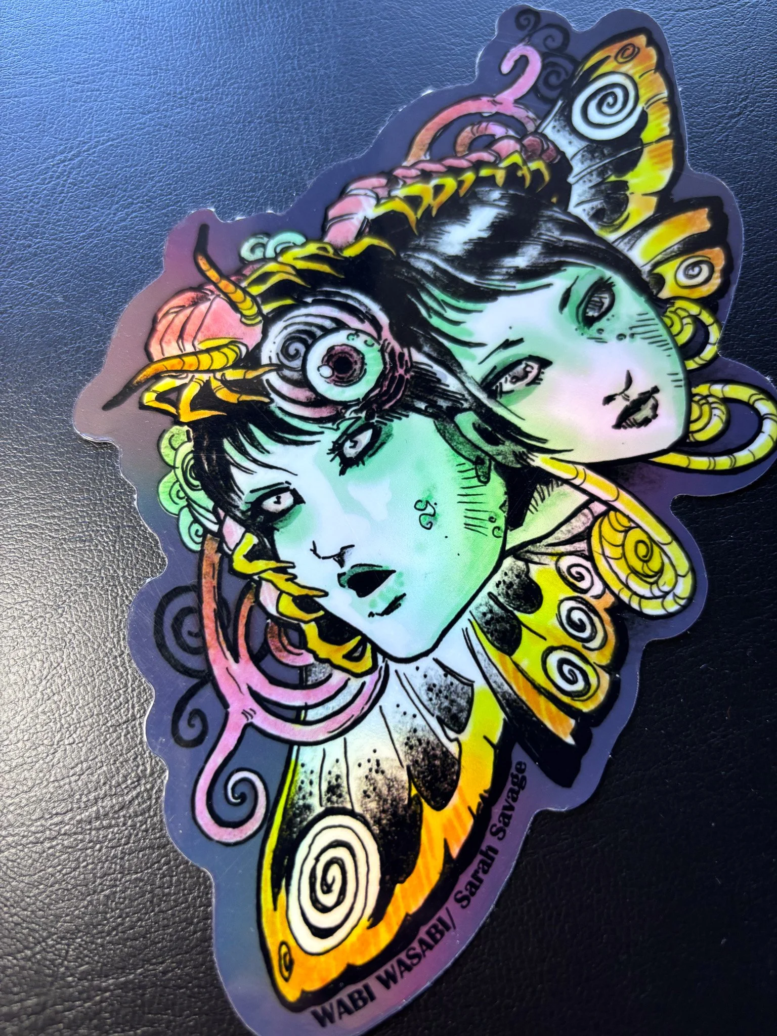 Artistic sticker of a woman with butterfly wings, insect antennae, and multiple eyes, featuring vibrant colors and intricate designs.