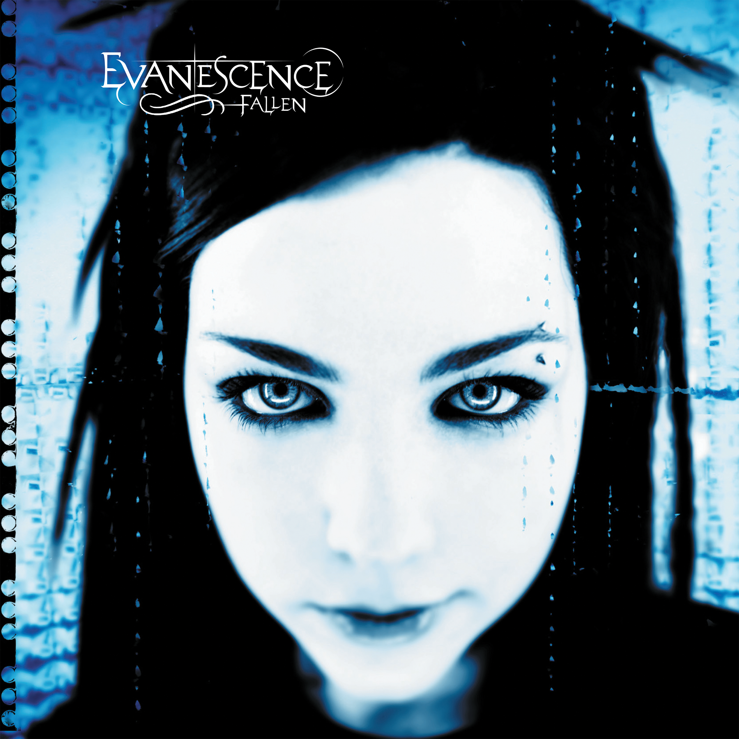 Close-up of a woman's face with light blue eyes, dark hair with dreadlocks, and makeup. Text in the upper left corner reads 'Evanescence Fallen.'
