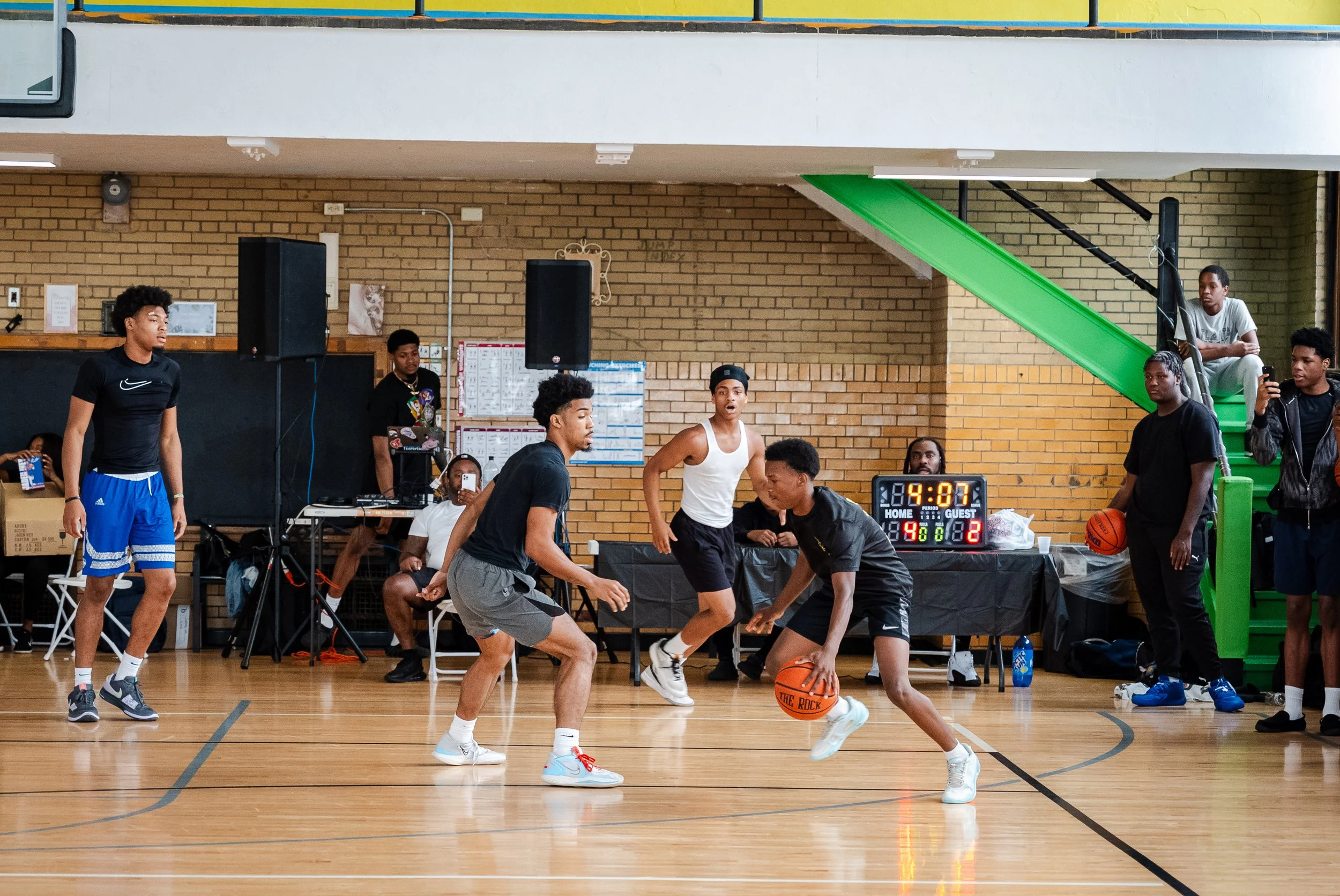 Young players practicing basketball at an indoor court during a game or practice.