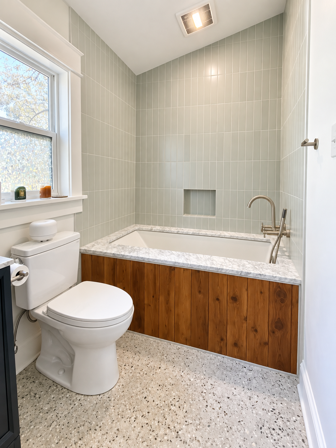 Bathroom with a toilet and a bathtub with a marble ledge and wood paneling, green tiled walls, a window with candles, and a ceiling vent.