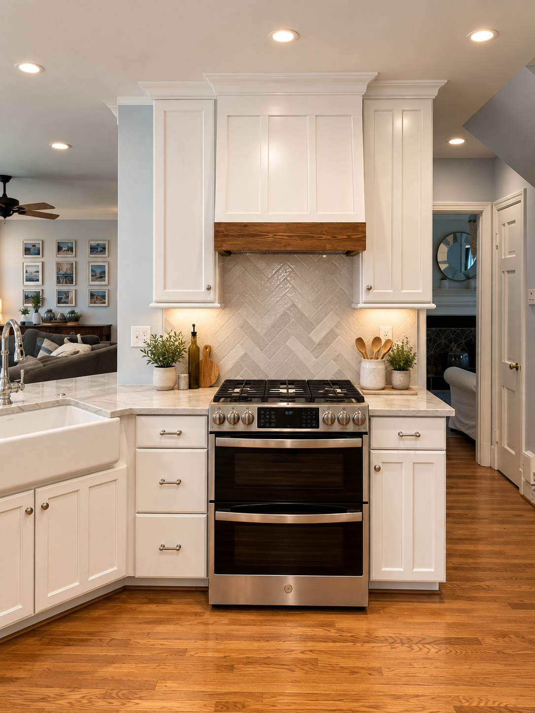 Modern kitchen with white cabinets, stainless steel stove, beige tile backsplash in herringbone pattern, and wood accents, with potted plants and cooking utensils.