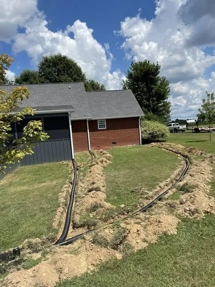 Underground gutter drain pipe installed in trench for stormwater runoff control